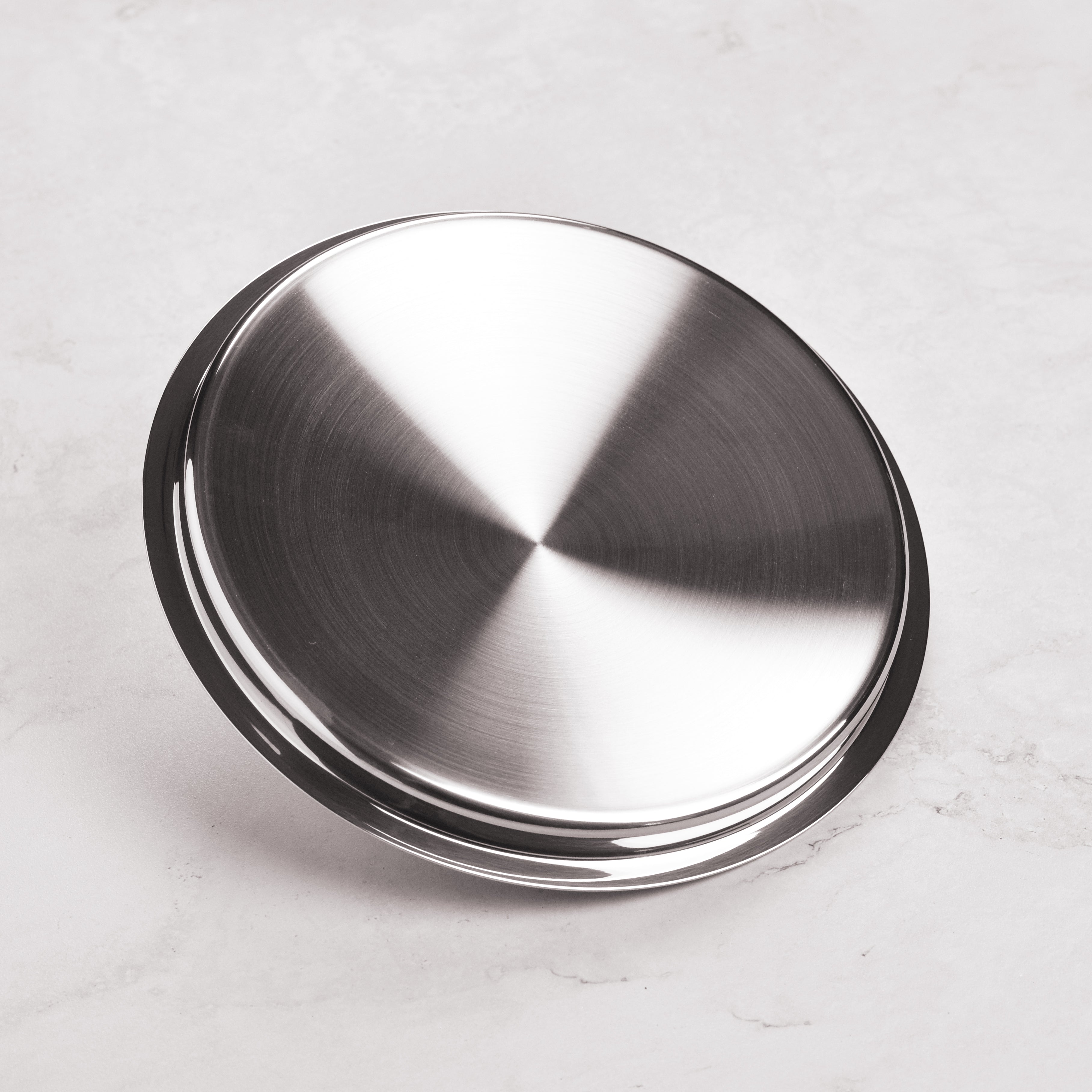 Hestan stainless steel lid on a skillet, demonstrating its snug fit and heat retention capabilities.