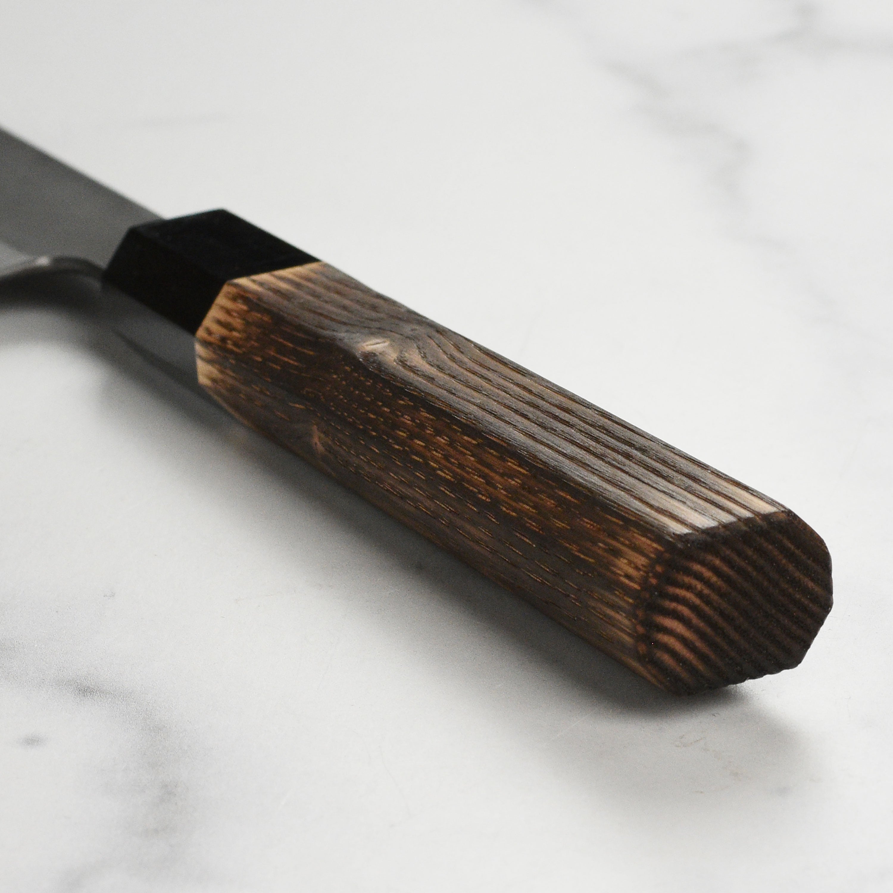 Close-up of the Hinoura 9.4" Sujihiki Knife demonstrating its precision cutting capabilities.