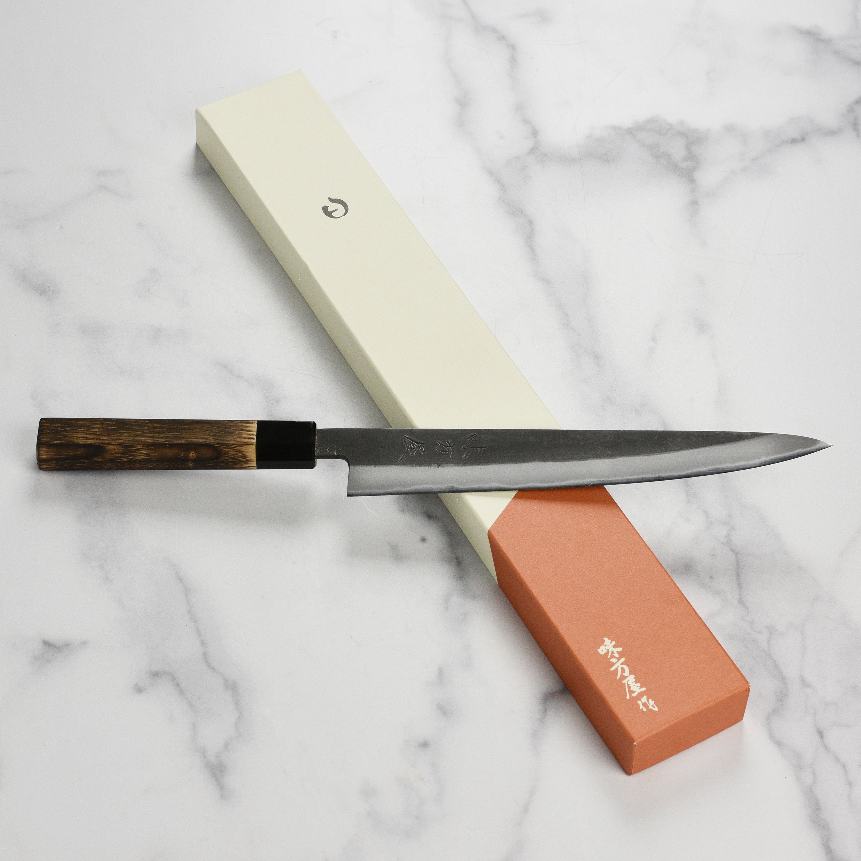 Hinoura Shirogami Sujihiki Knife showcasing sharp blade and elegant design.