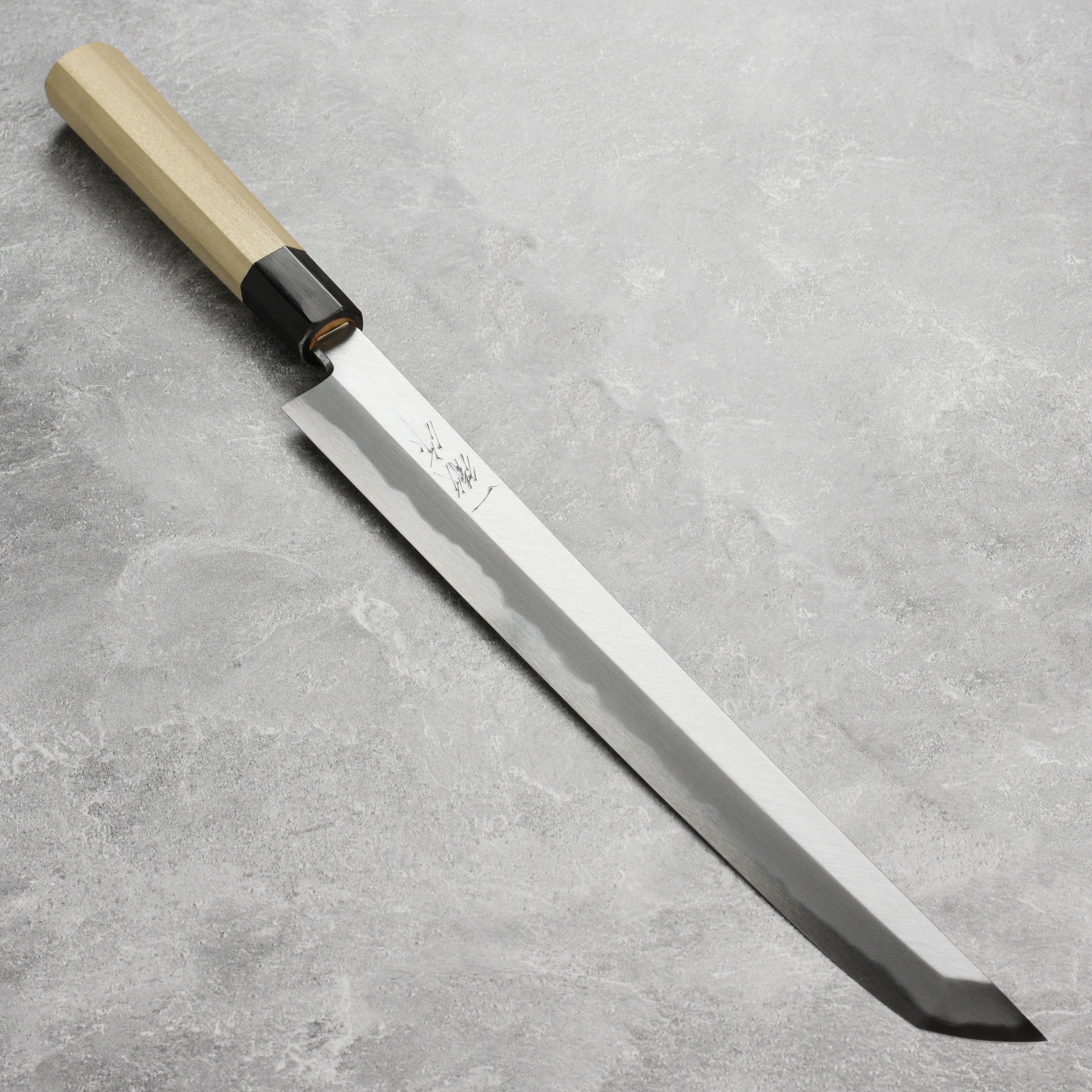 Affordable Takohiki knife with saya resting on a wooden cutting board, ideal for professional chefs.