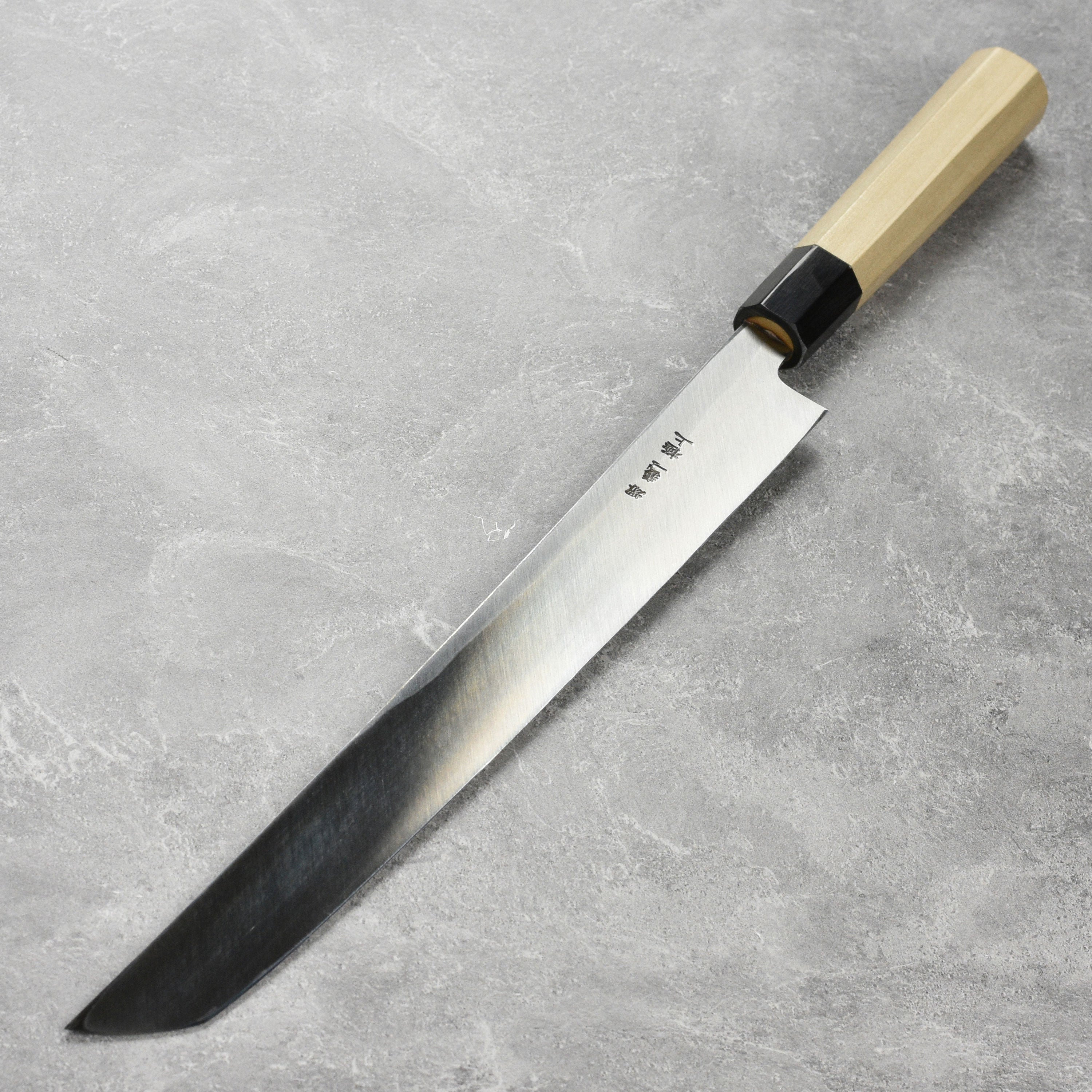 High carbon chef knife displayed with sushi ingredients, highlighting its precision and quality.