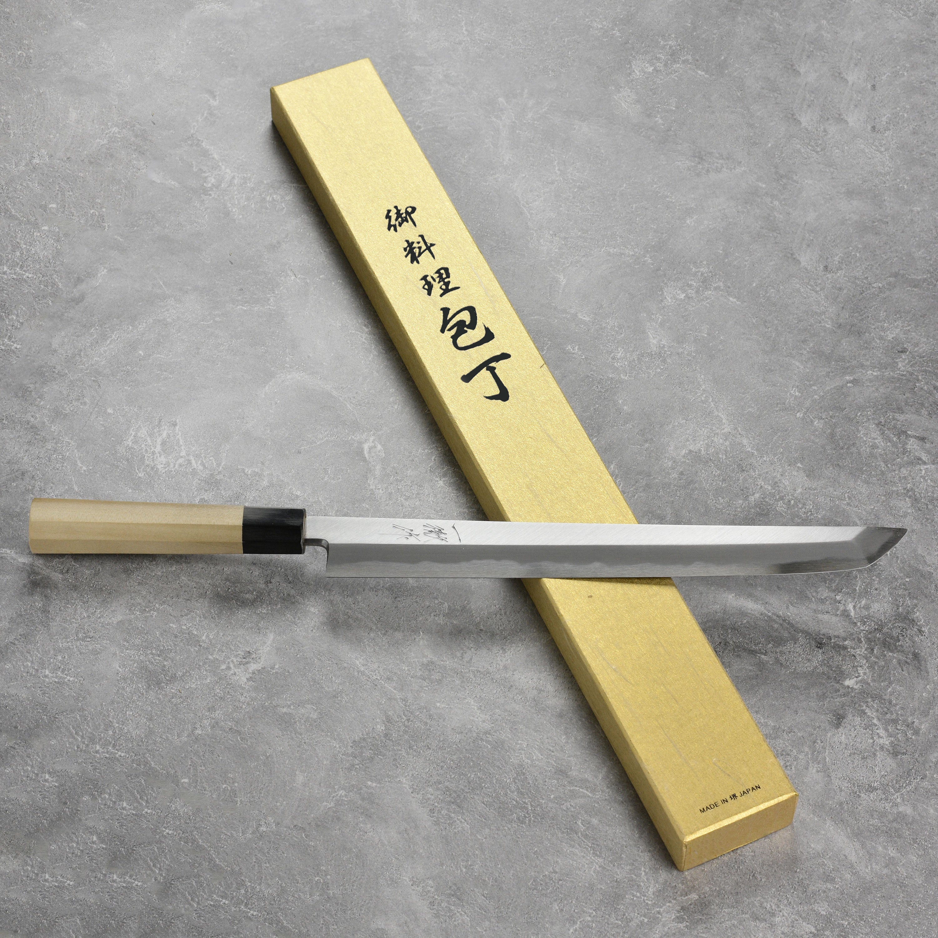 High carbon chef knife displayed with sushi ingredients, highlighting its precision and quality.