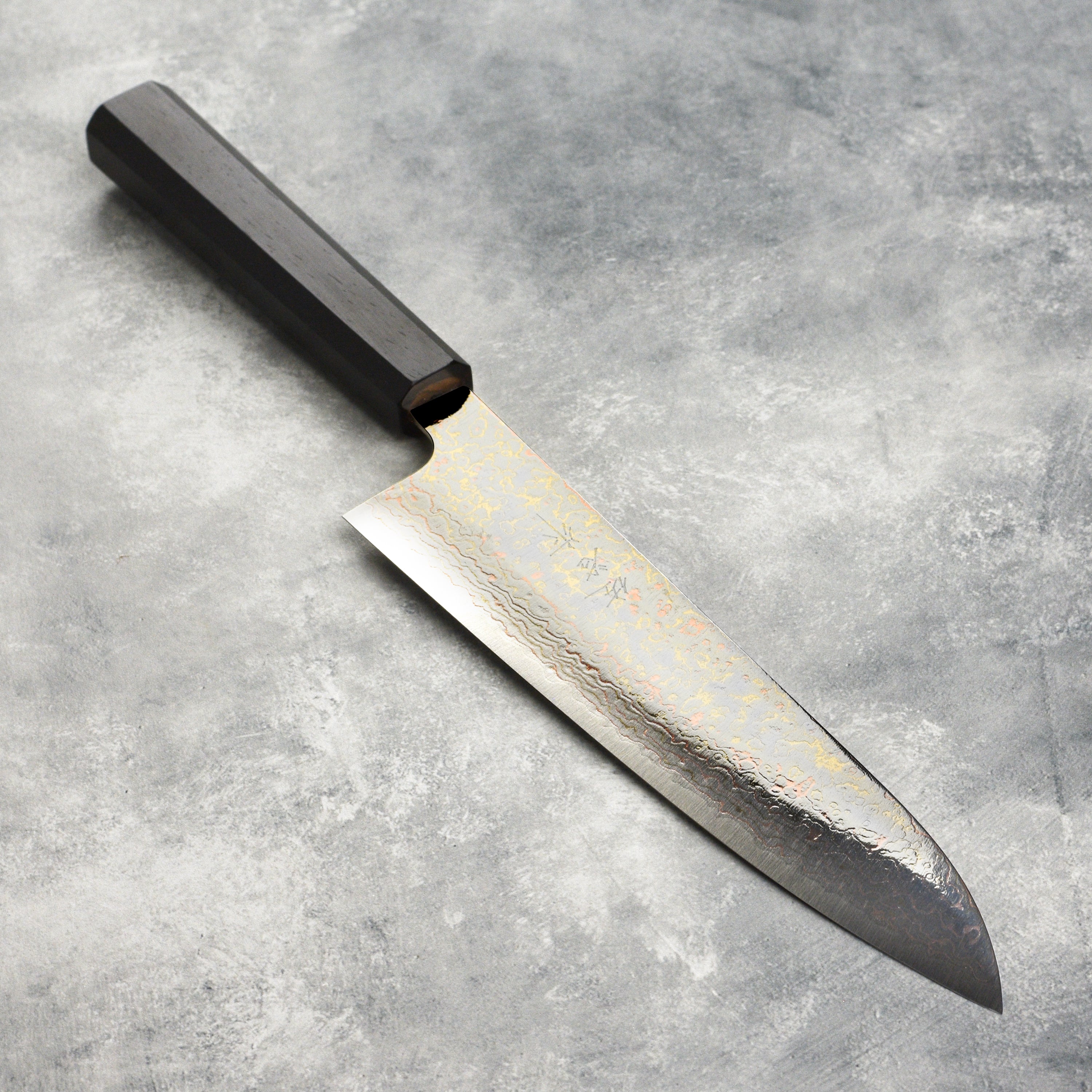 Close-up of the rainbow damascus gyuto knife blade highlighting layered steel and vibrant colors