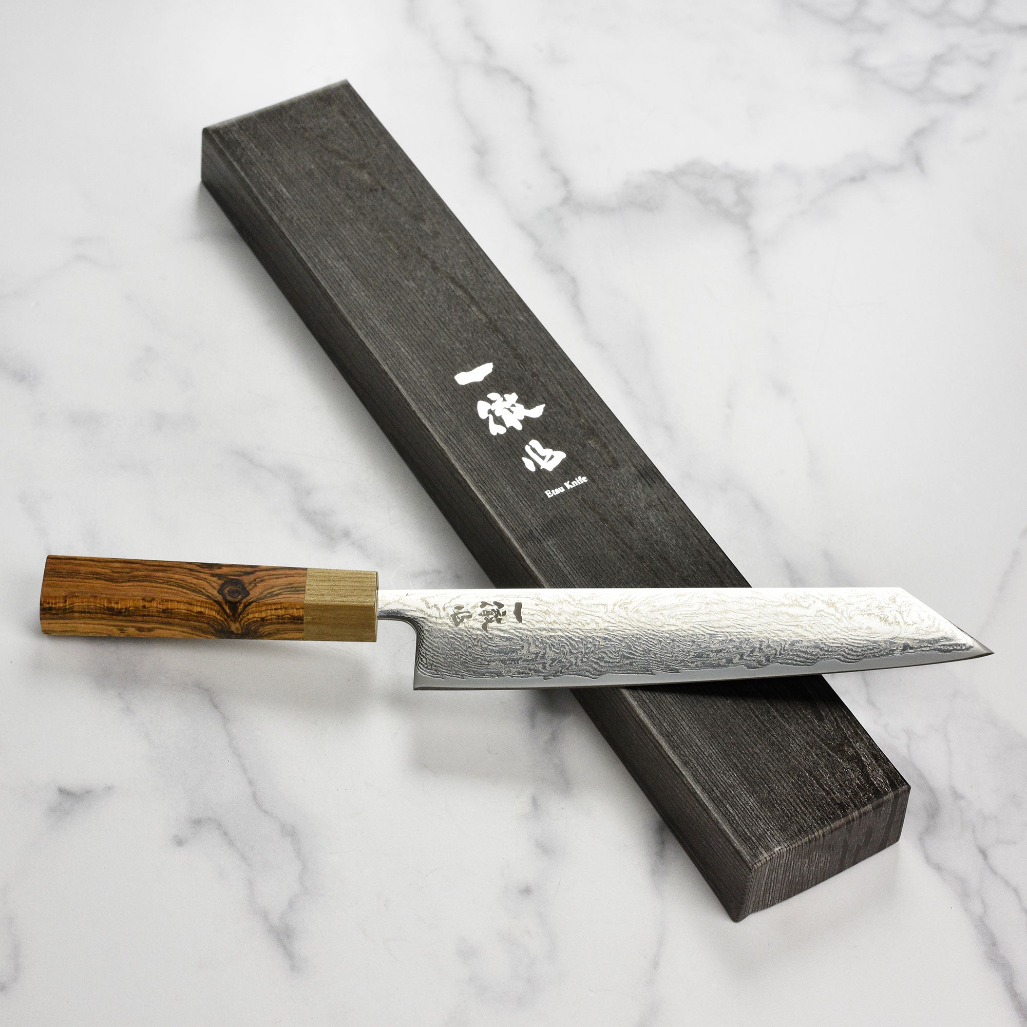 Close-up of the sharp edge and ergonomic handle of the Damascus chef knife