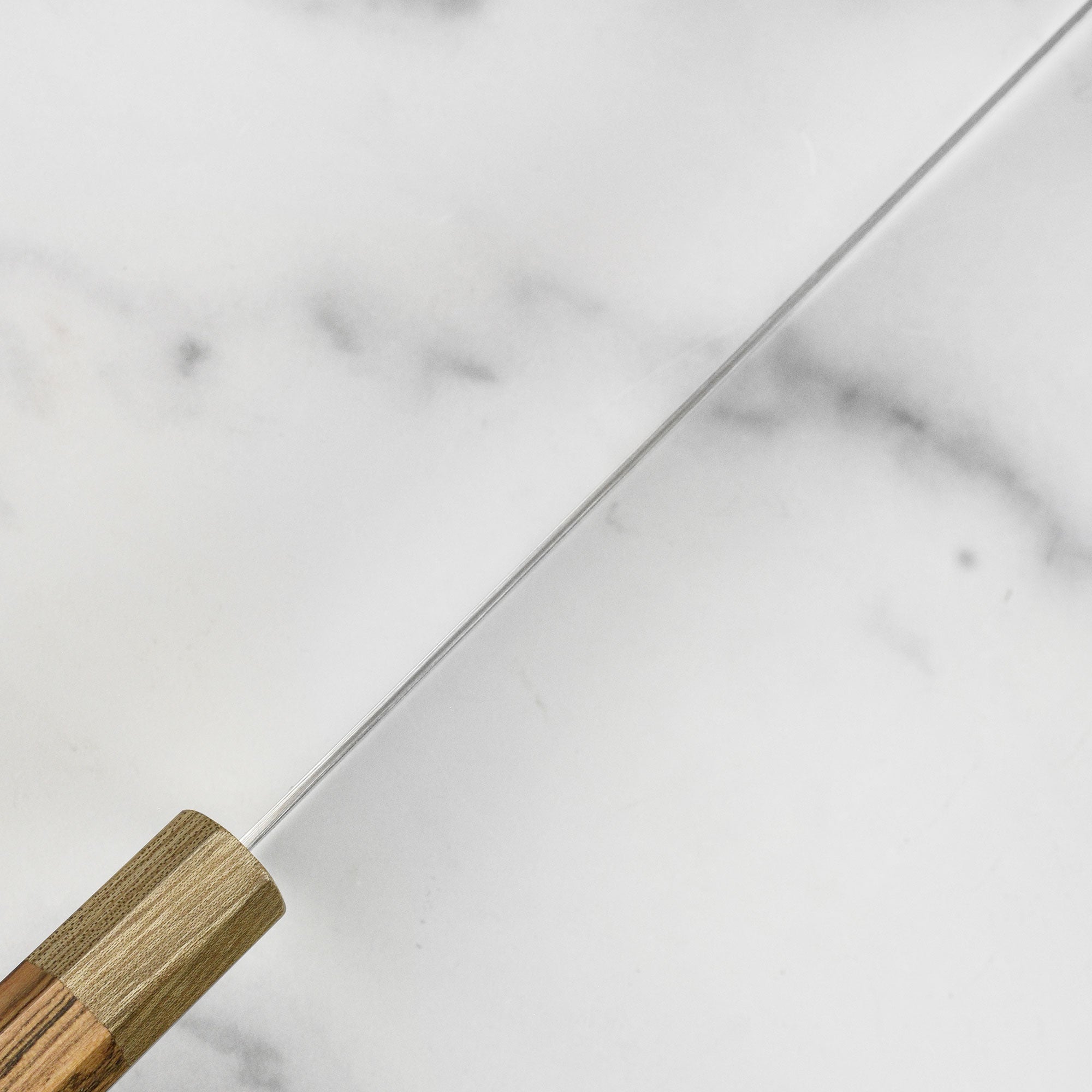 Close-up of the sharp edge and ergonomic handle of the Damascus chef knife