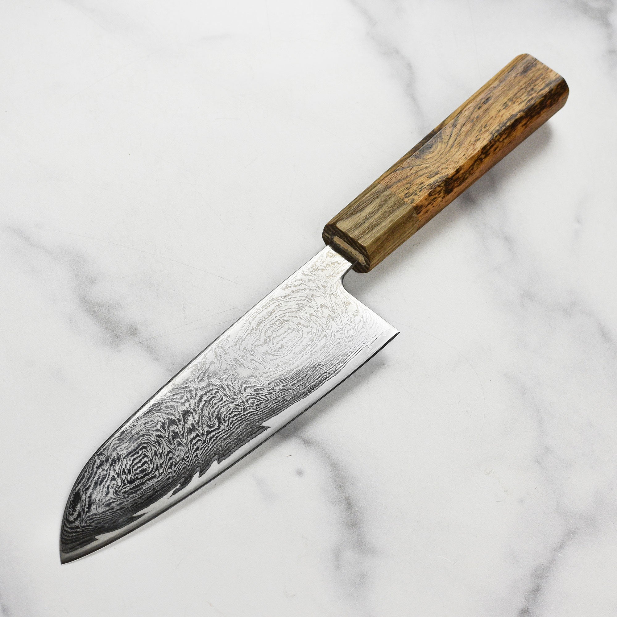 Close-up of the Ittetsu Santoku knife demonstrating the intricate spiral Damascus pattern on the blade.