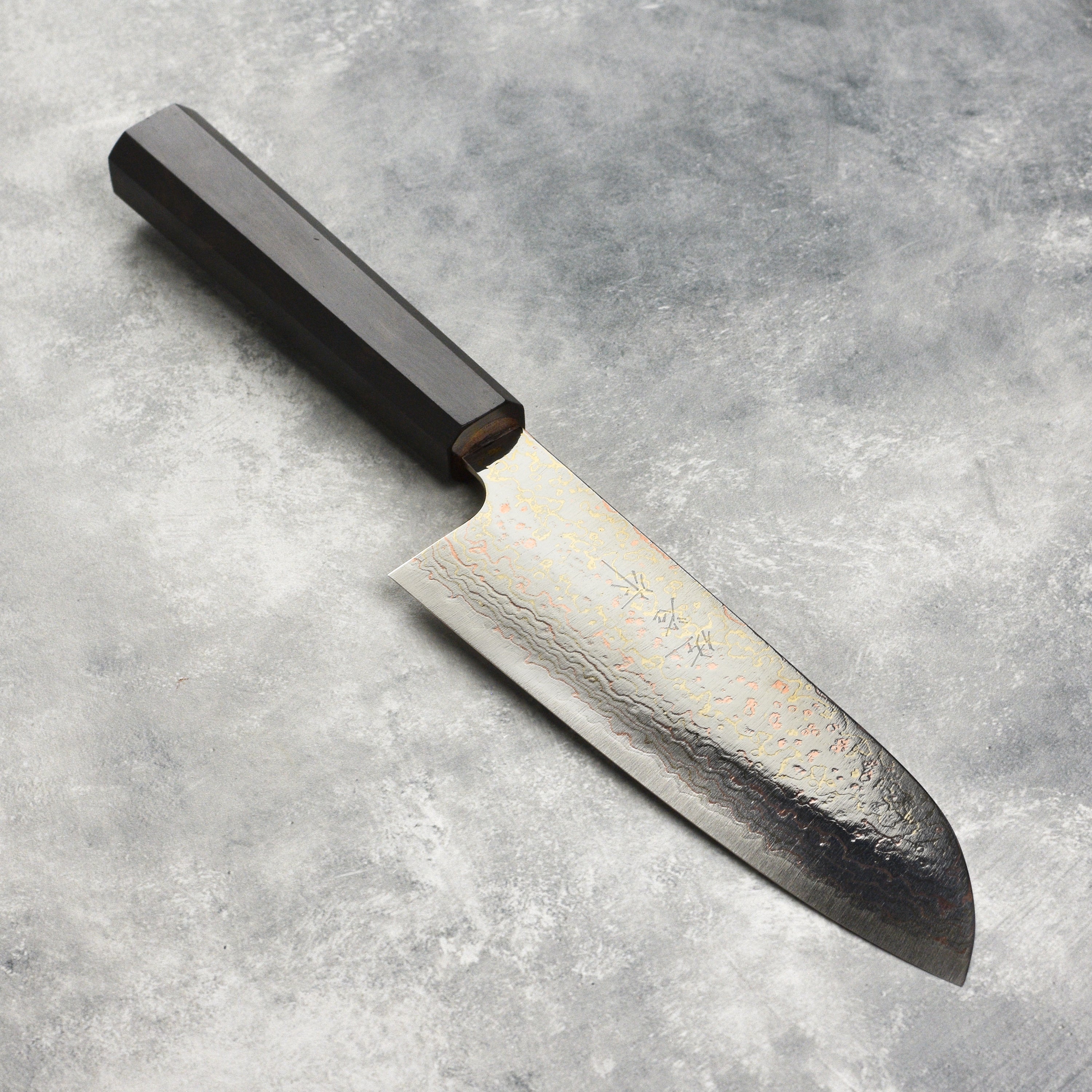 Close-up view of the Saji Rainbow Damascus Santoku knife blade highlighting the colorful Damascus pattern.