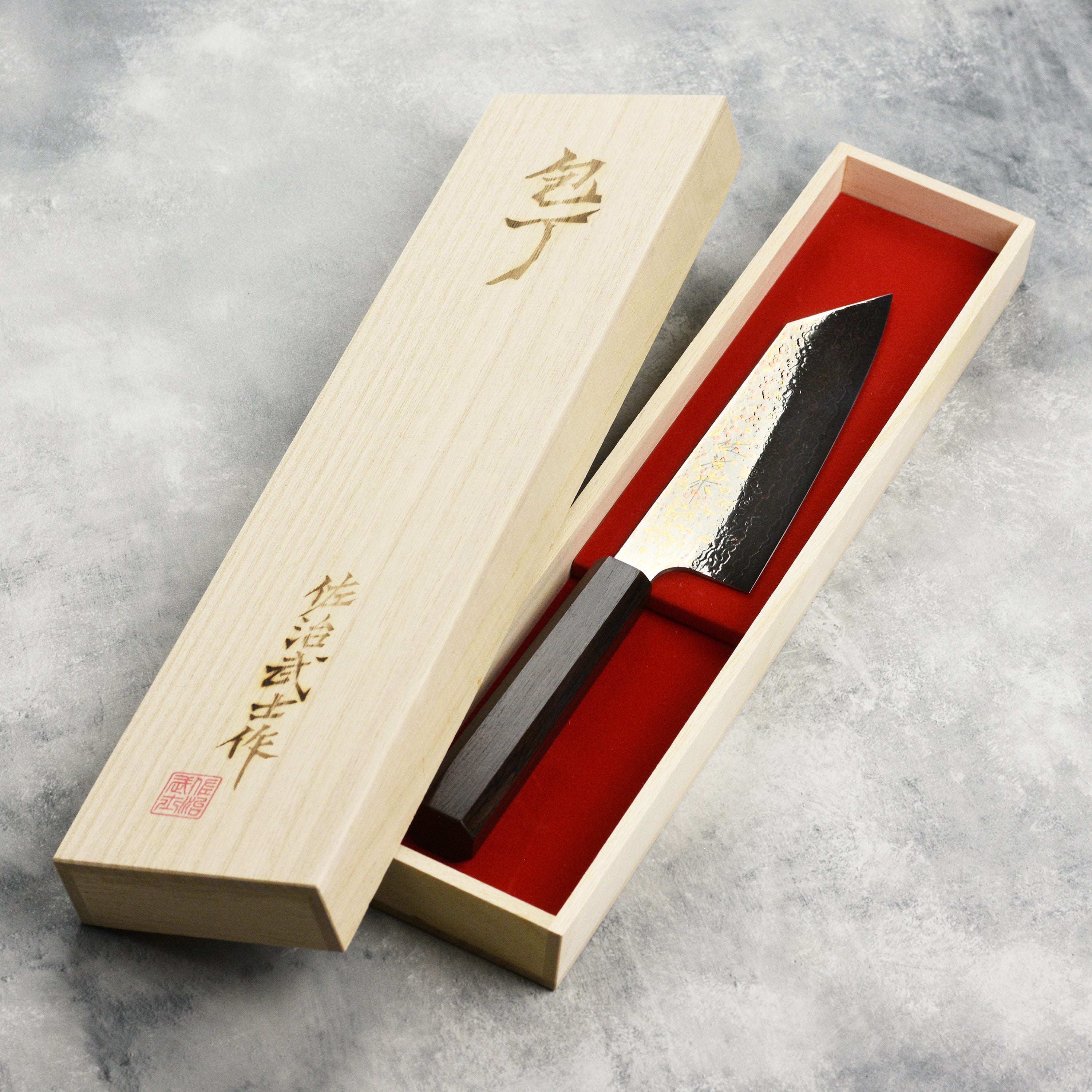 Close-up of the ebony wood handle of the Saji Bunka Chef Knife, highlighting its elegant design.