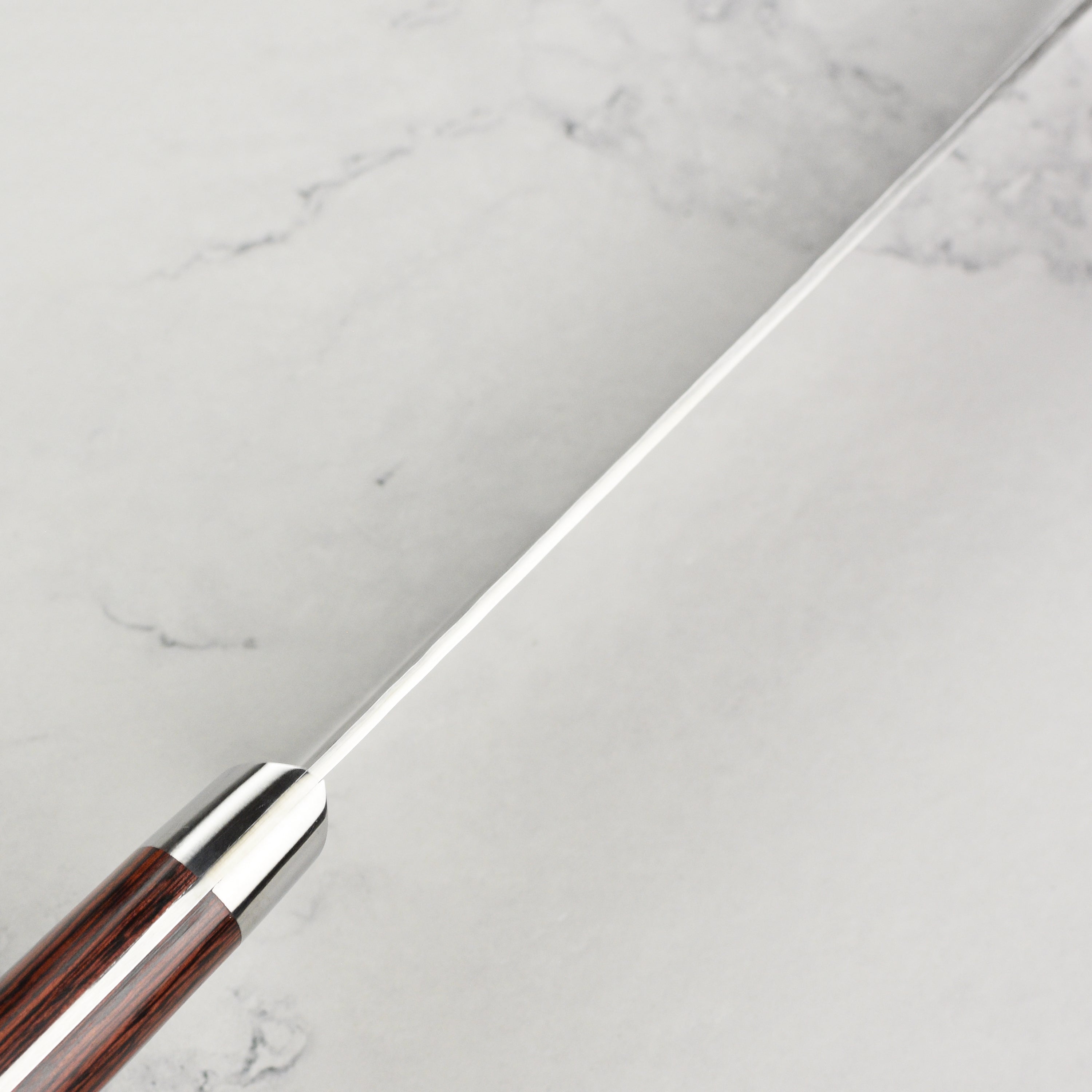 Close-up of the full-tang mahogany Pakkawood handle of the Sakai Artisan butcher knife.