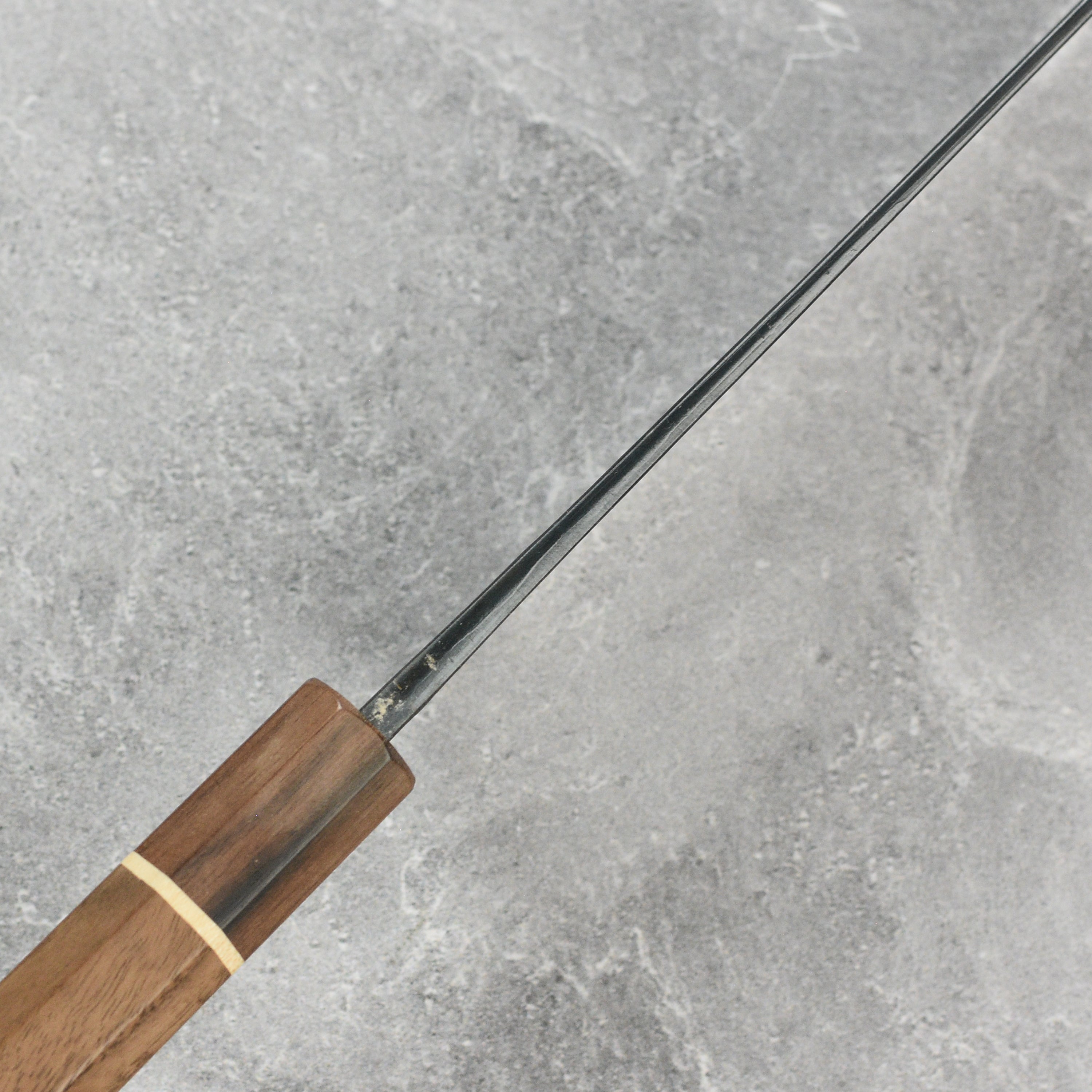 Nishida Shirogami Funayuki Gyuto Knife in use, slicing fresh vegetables on a wooden cutting board.
