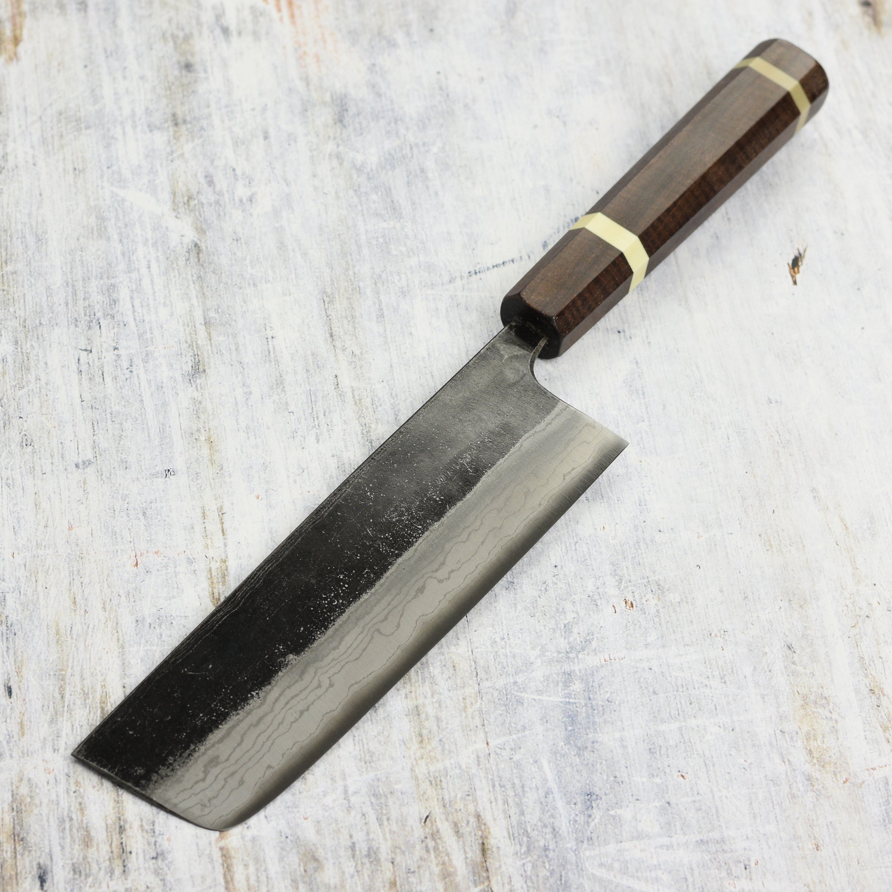 Hatsukokoro Nakiri Knife in action, slicing fresh vegetables with precision.