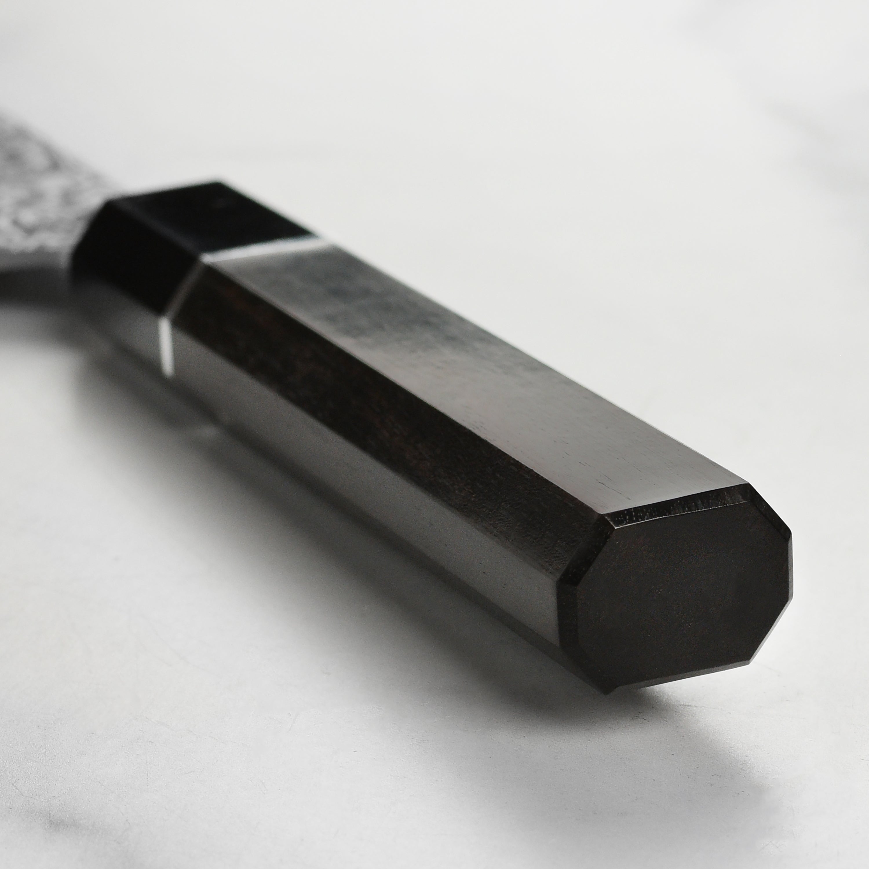 Saji SG2 Nakiri knife placed on a cutting board, highlighting its ebony handle and buffalo horn ferrule.
