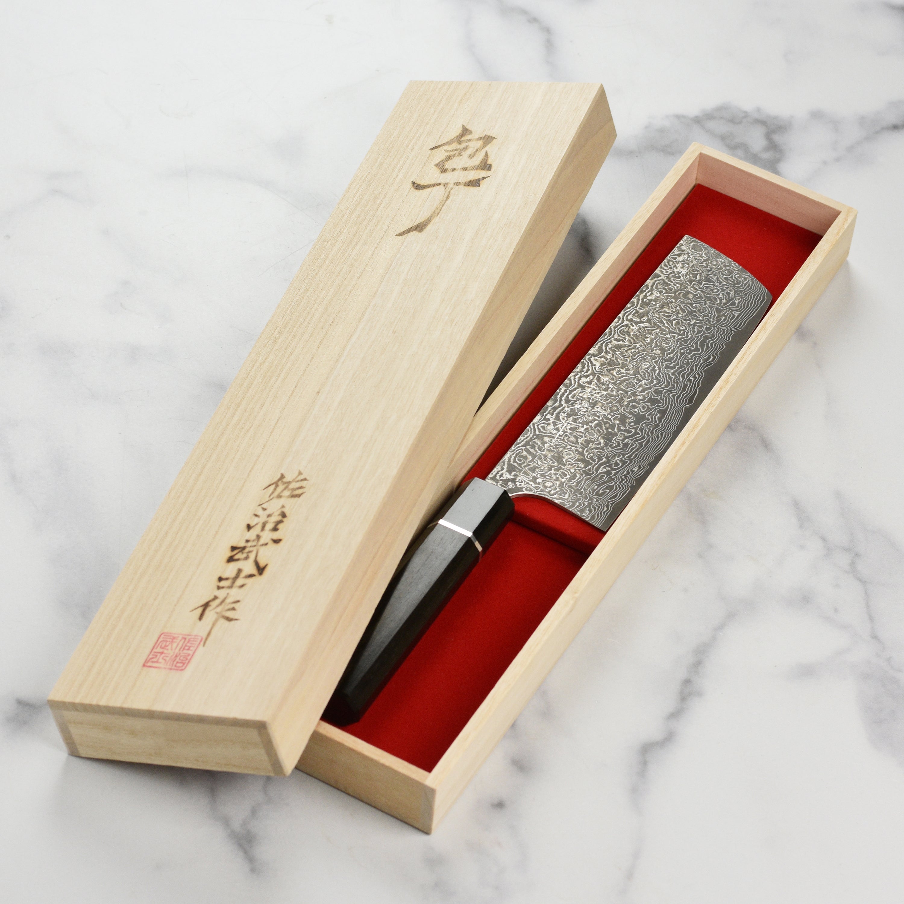 Close-up of the Saji SG2 Black Damascus Nakiri knife blade showcasing its intricate design.