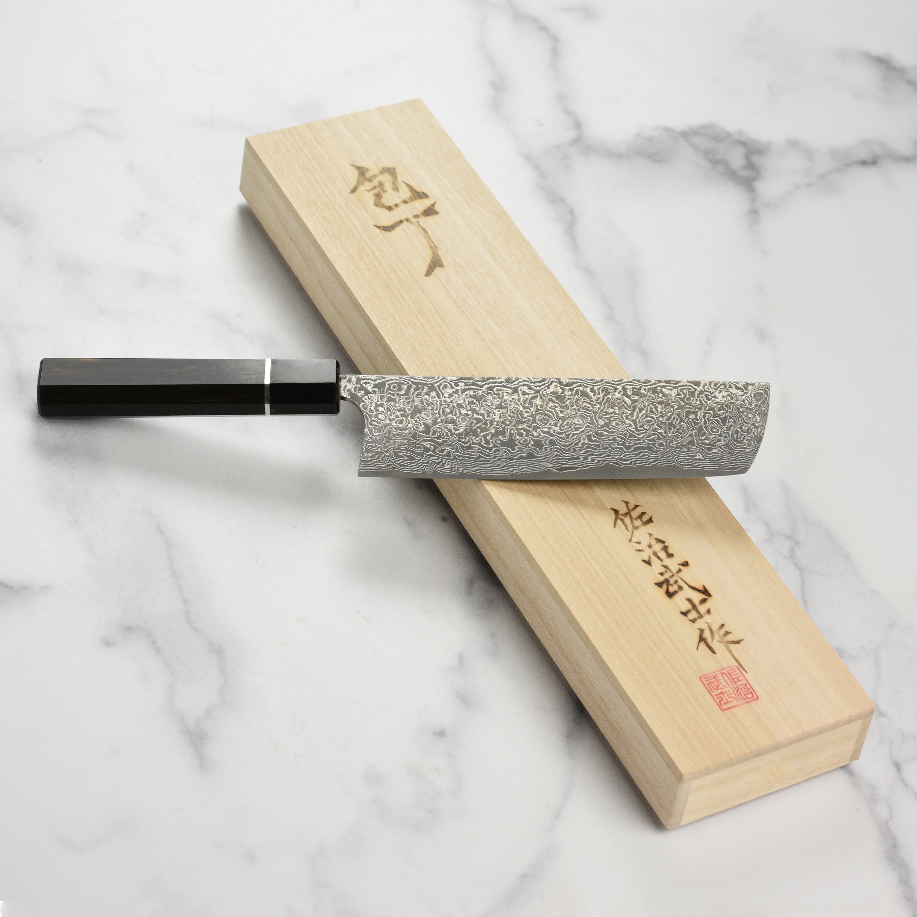 Close-up of the Saji SG2 Black Damascus Nakiri knife blade showcasing its intricate design.
