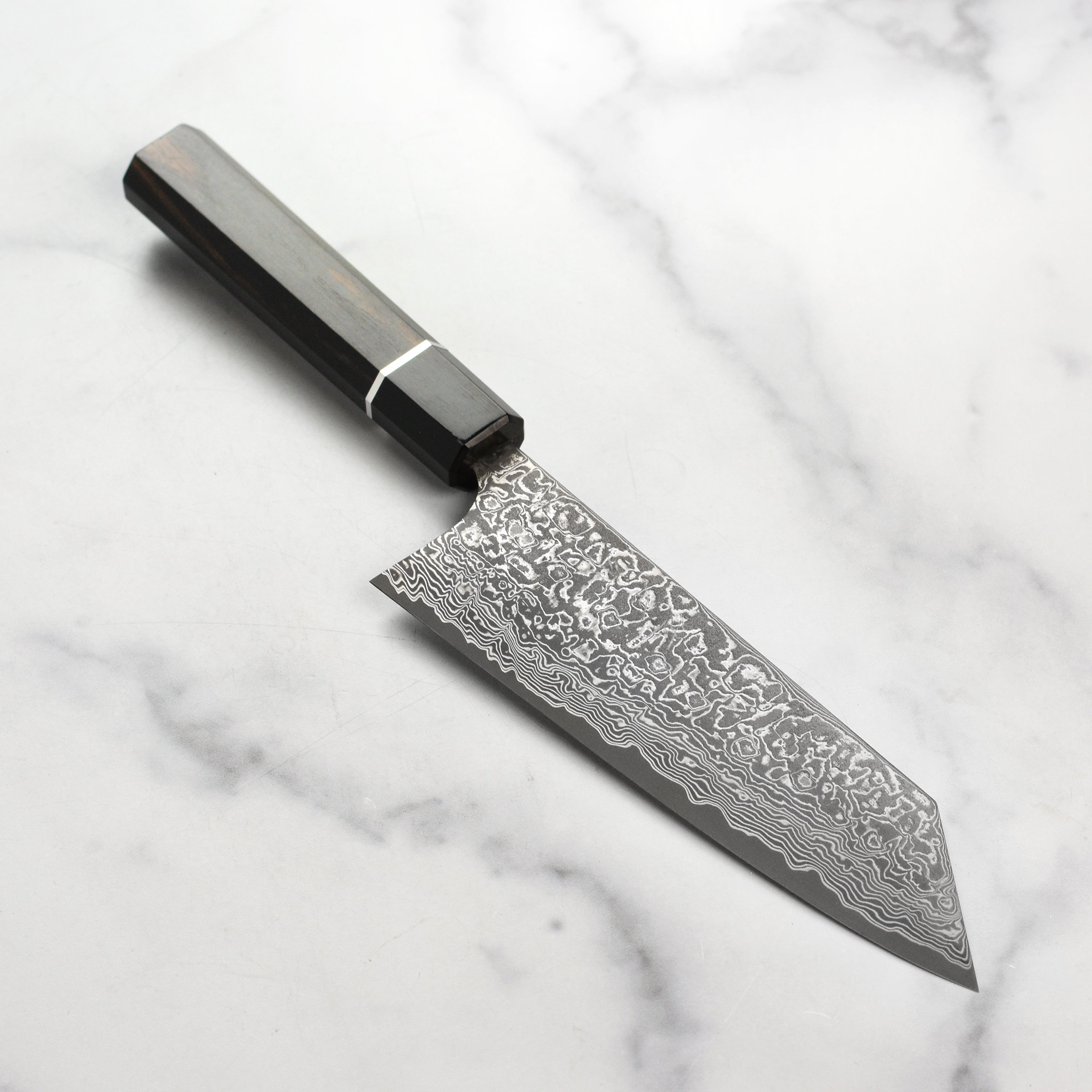 Close-up of Saji SG2 Damascus steel blade with dark finish