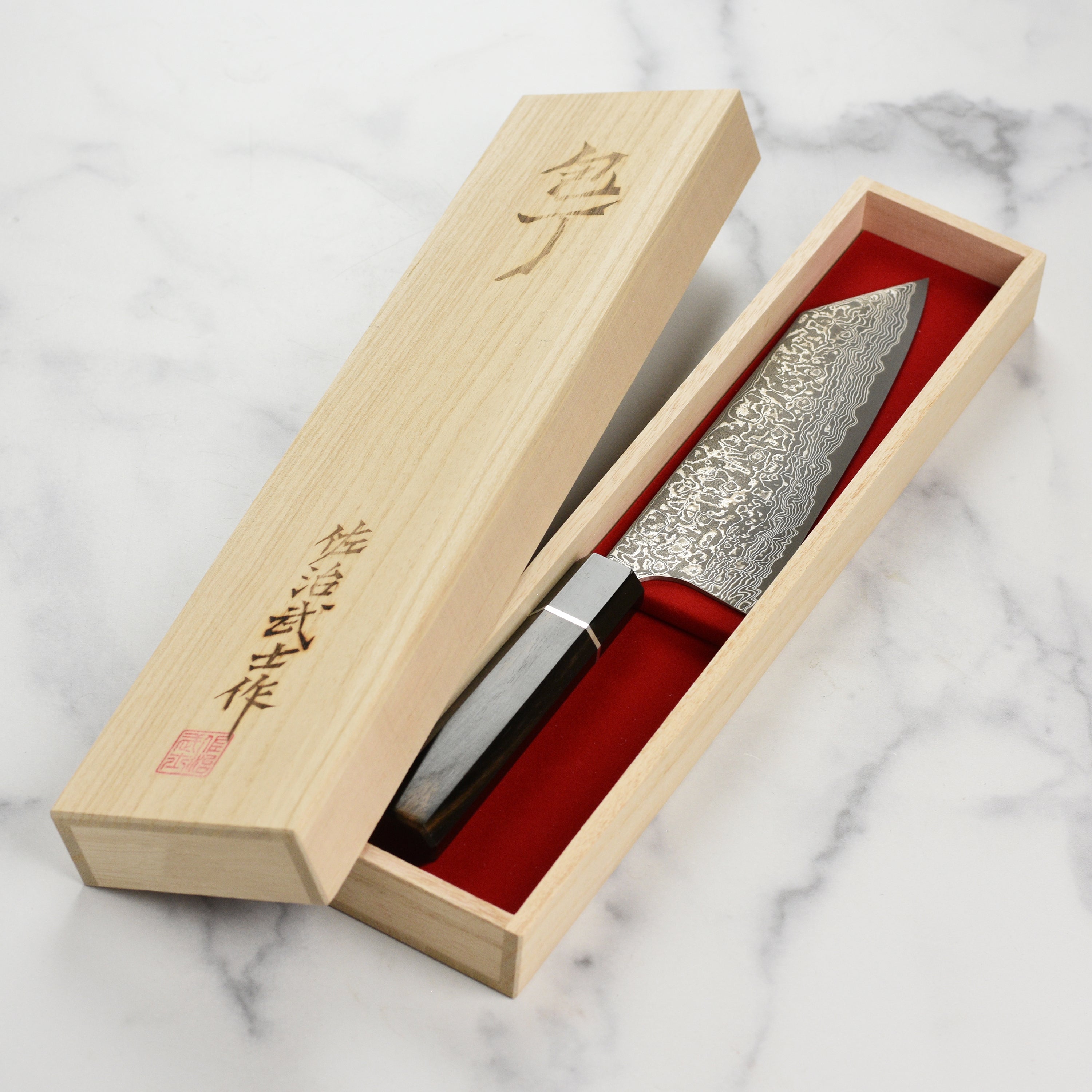Close-up of Saji SG2 Damascus steel blade with dark finish