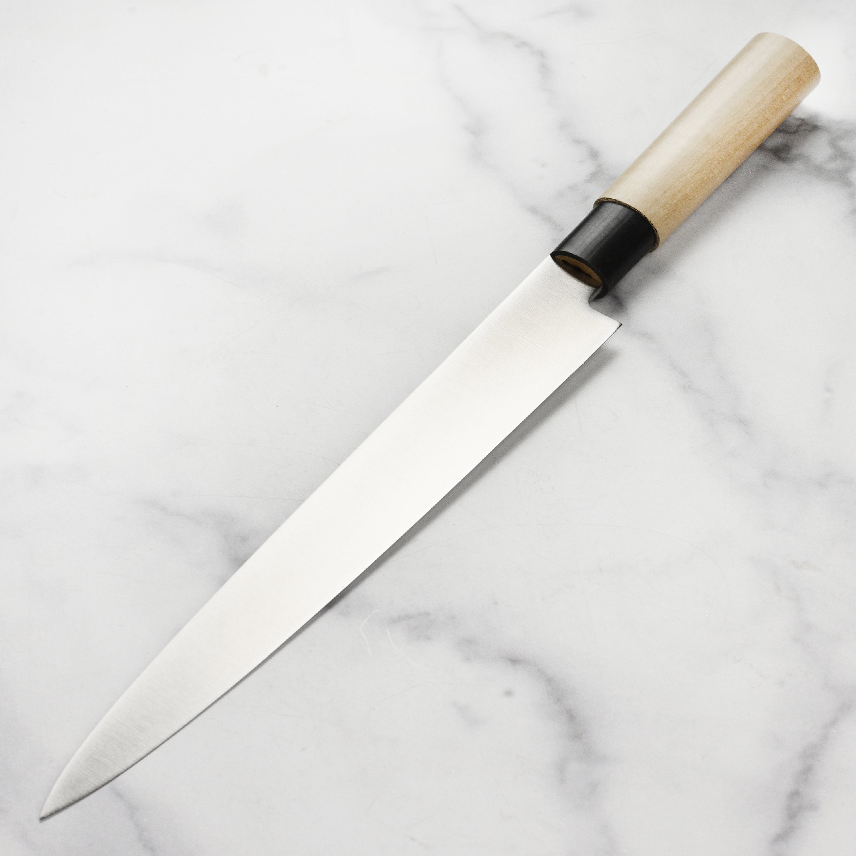 Close-up of the Tojiro MV yanagibas single bevel edge, highlighting its hand-sharpened precision.