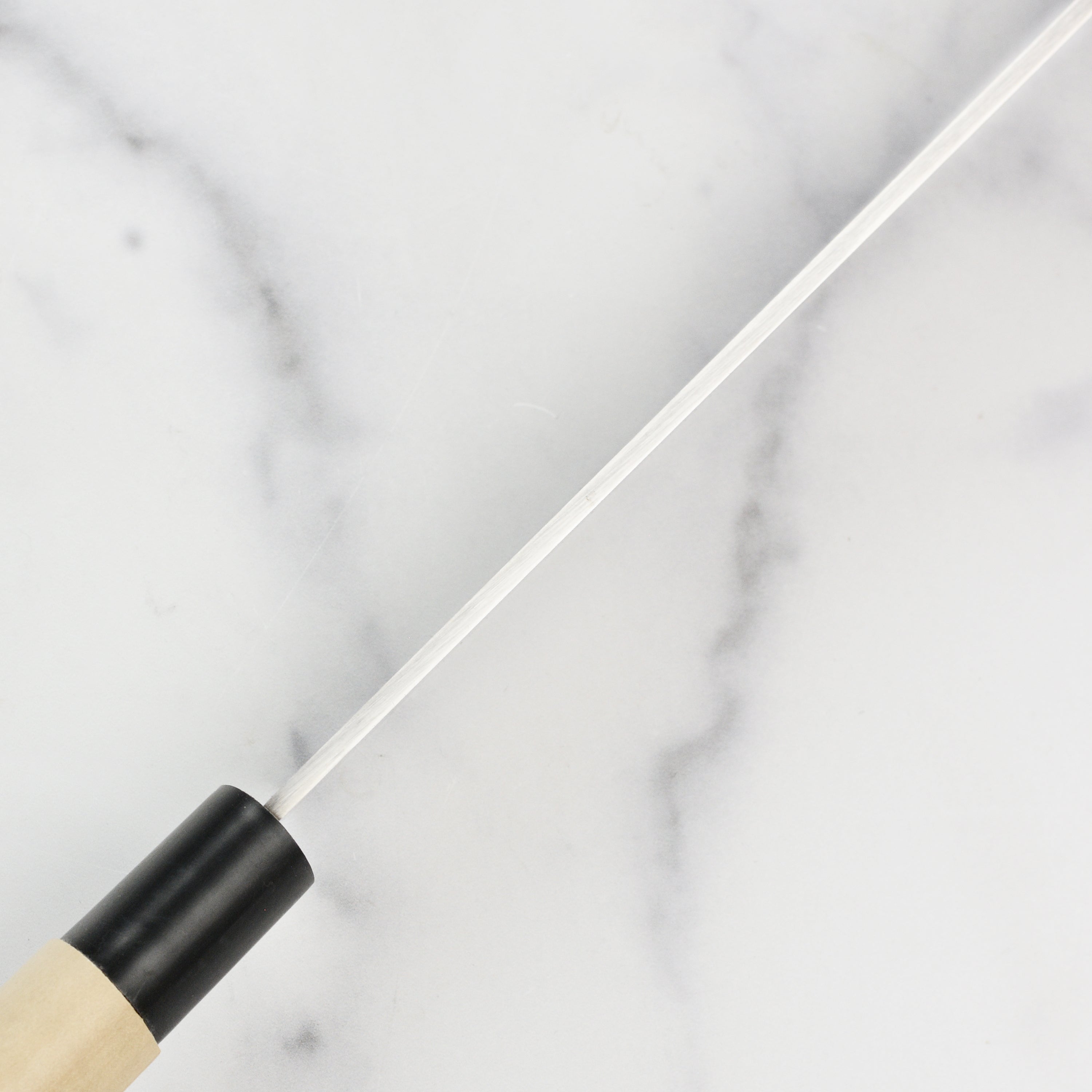 Tojiro MV knife placed on a cutting board, demonstrating its ideal use for slicing fish and sashimi.