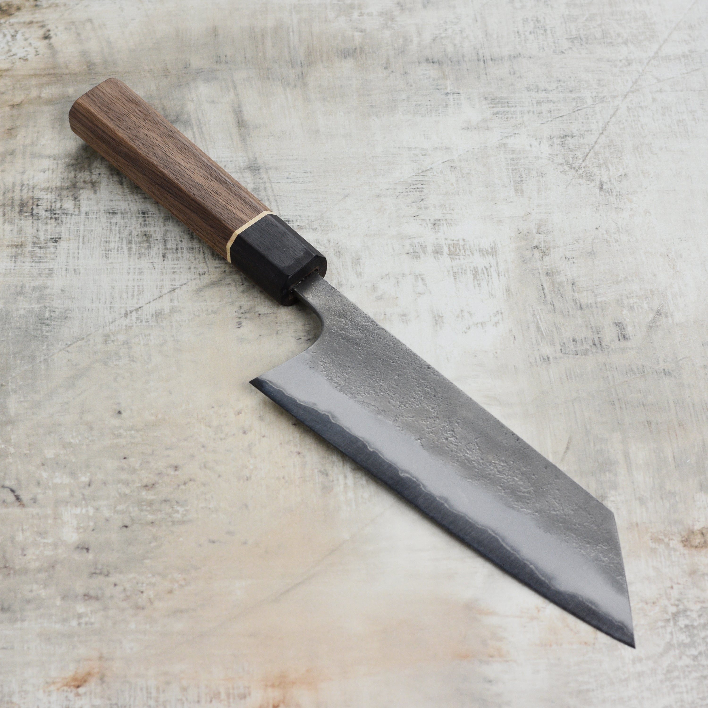 Close-up of the textured Nashiji finish on the blade of a Japanese Bunka knife for professional use