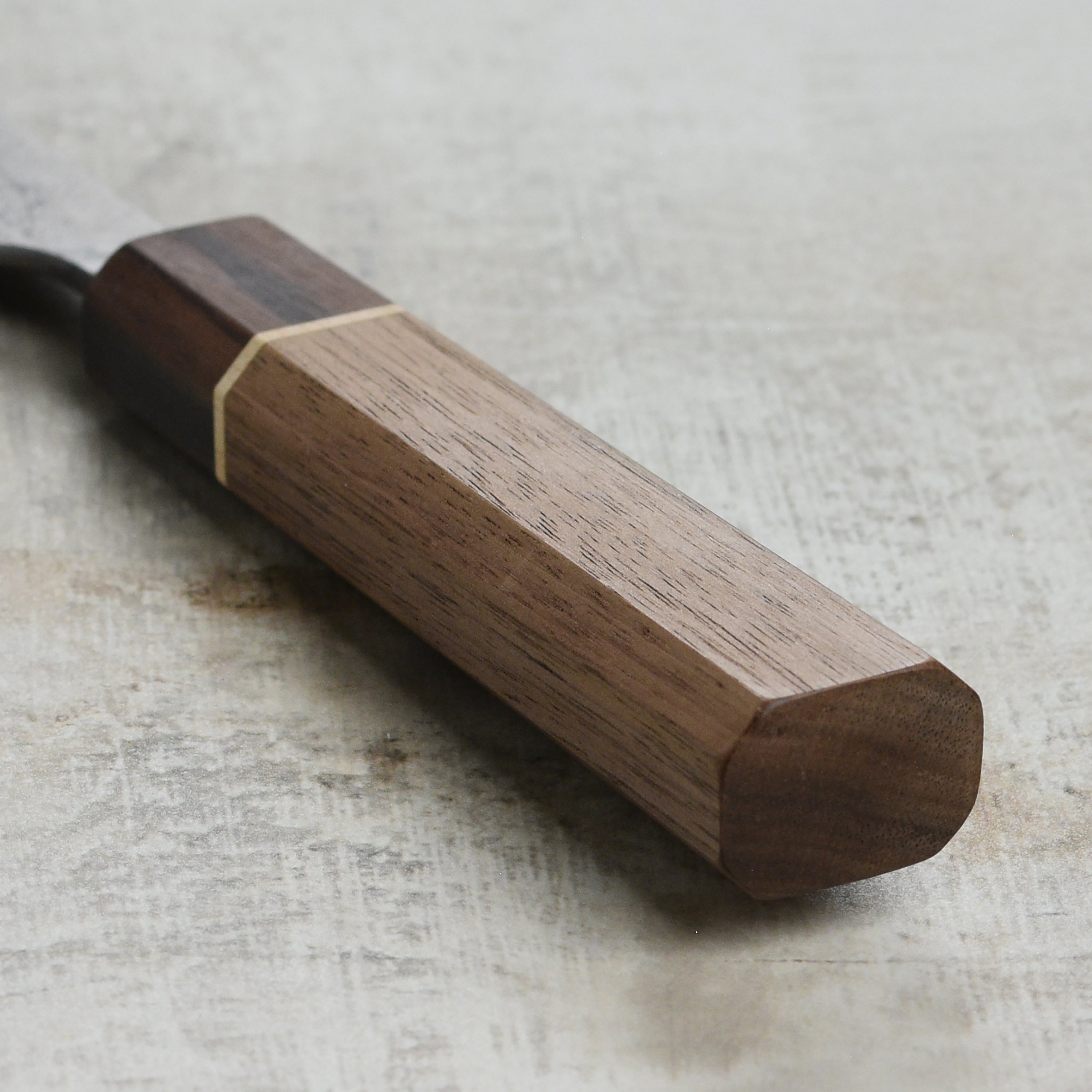 Close-up of the textured Nashiji finish on the blade of a Japanese Bunka knife for professional use