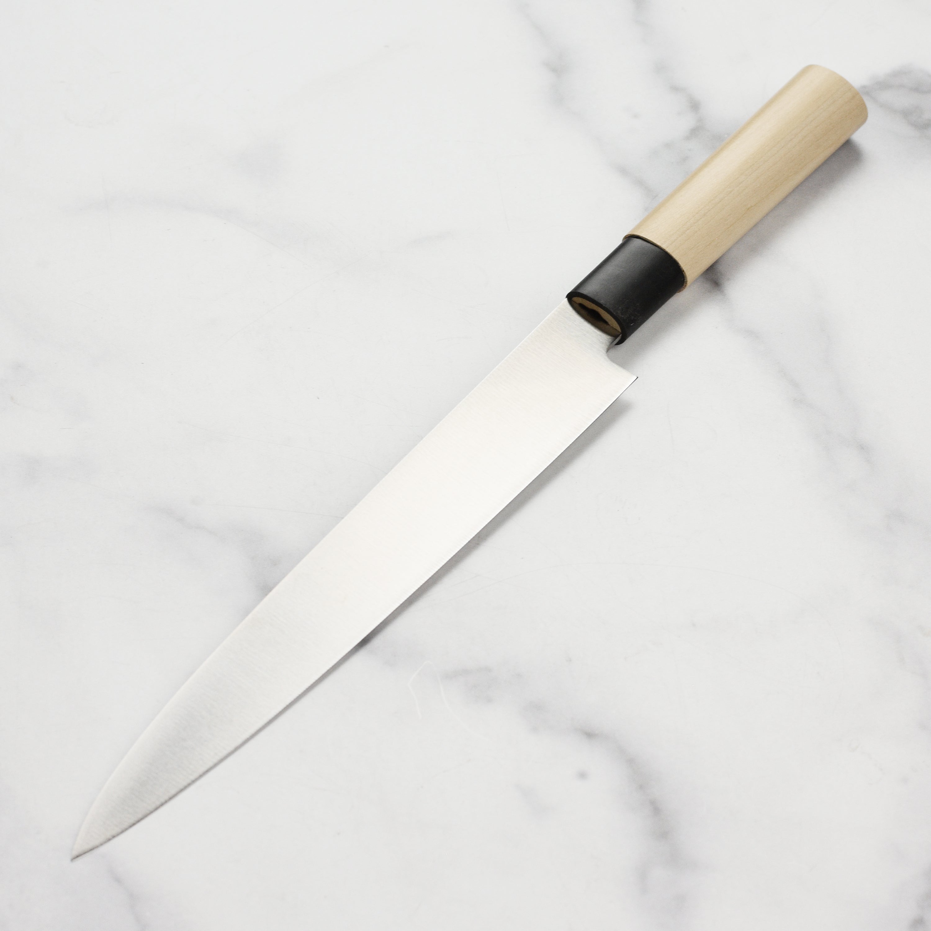 Japanese knife for sashimi slicing on a cutting board, highlighting its precision edge