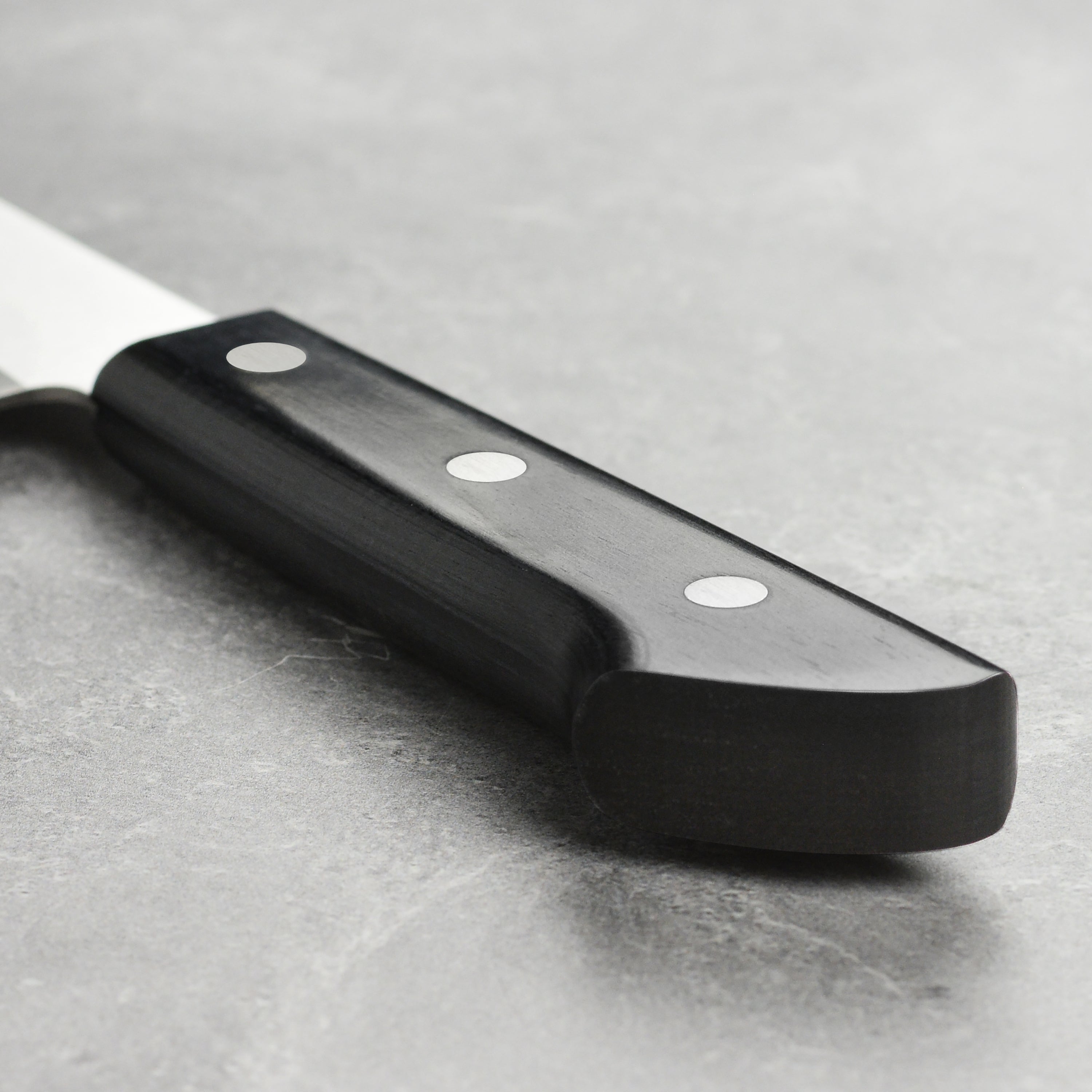 Tojiro chefs knife in action slicing herbs on a wooden cutting board, demonstrating its precision