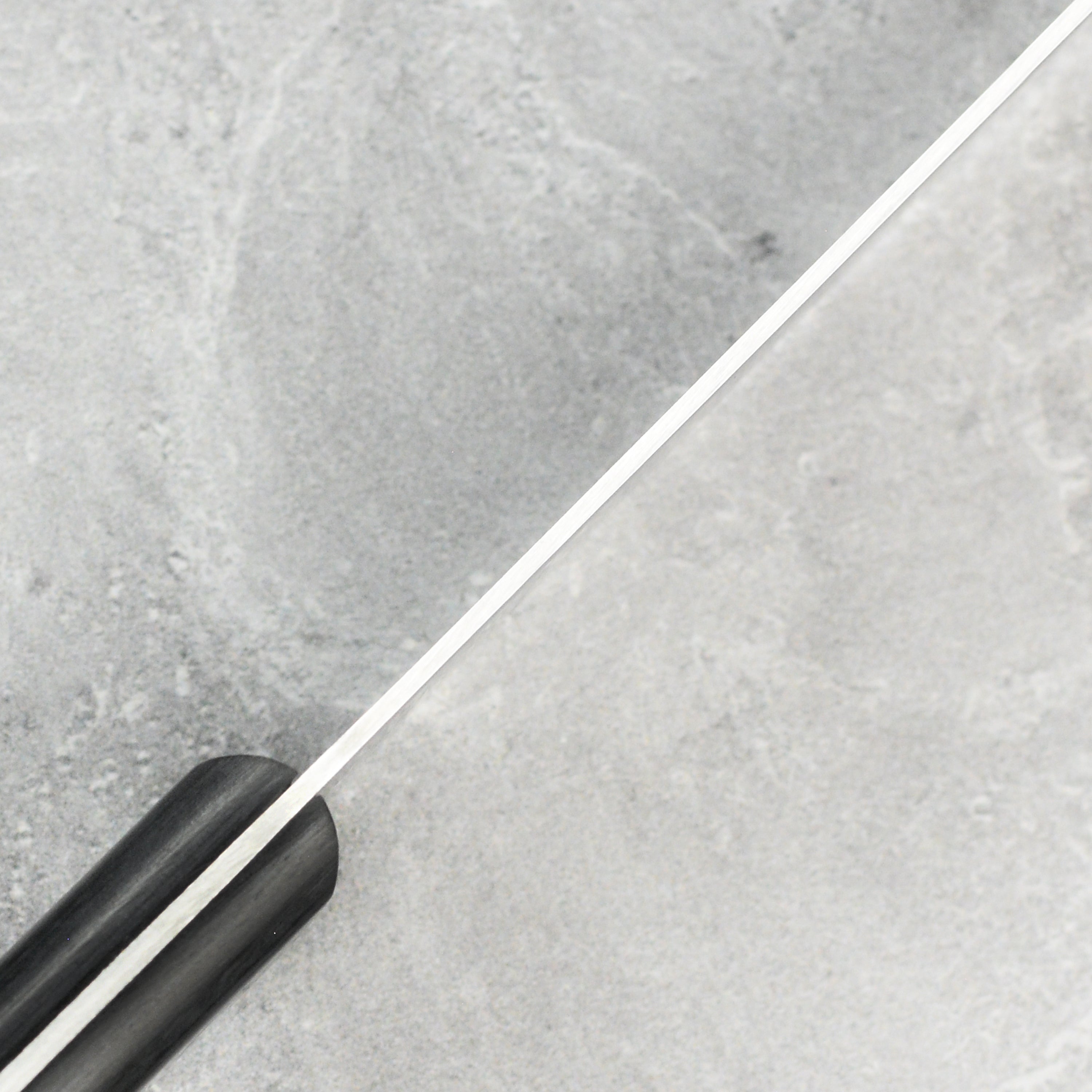 Close-up of the Pakkawood handle and rivets of the chefs knife, highlighting craftsmanship