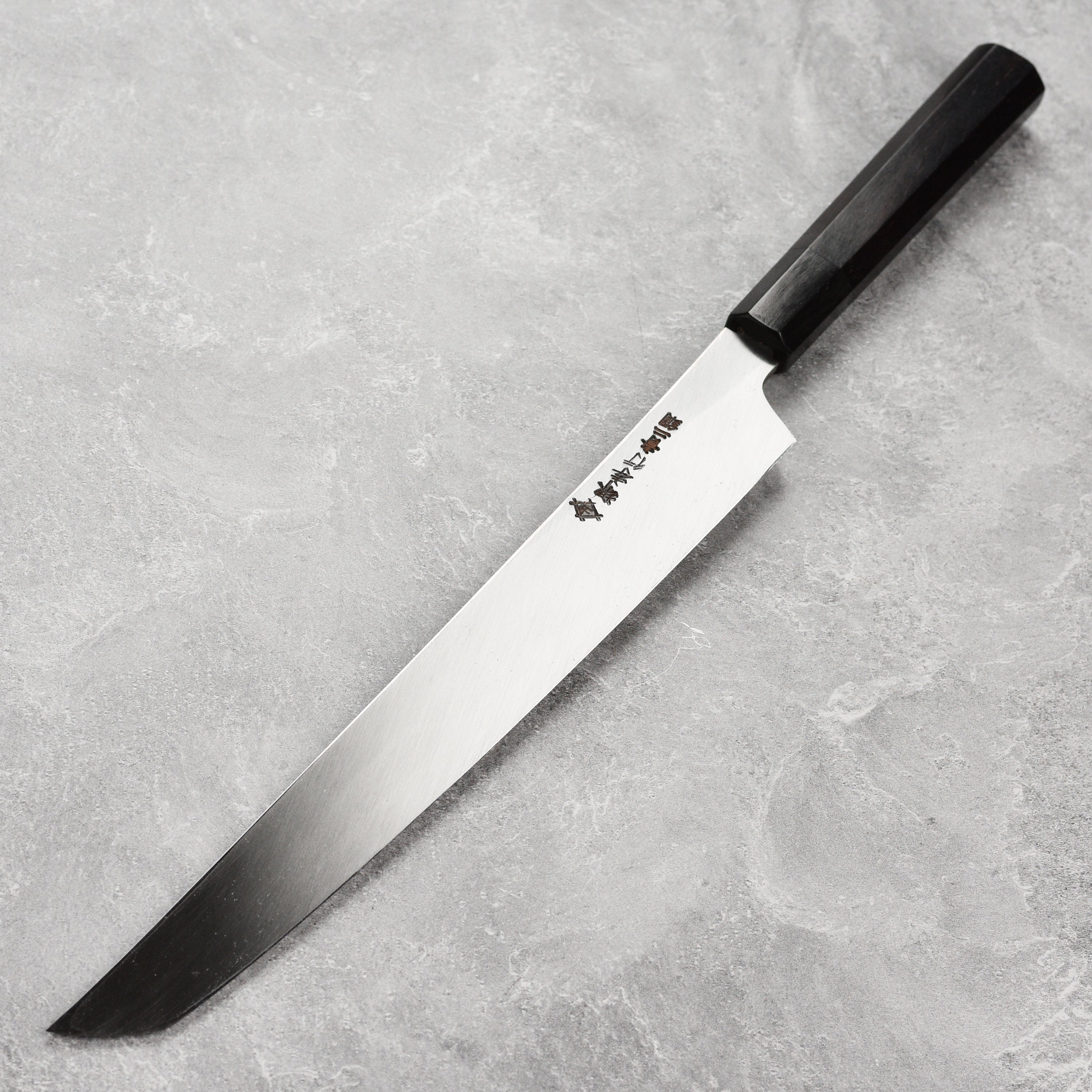 Close-up of Aogami Yanagiba knife showcasing its sharp edge and craftsmanship.