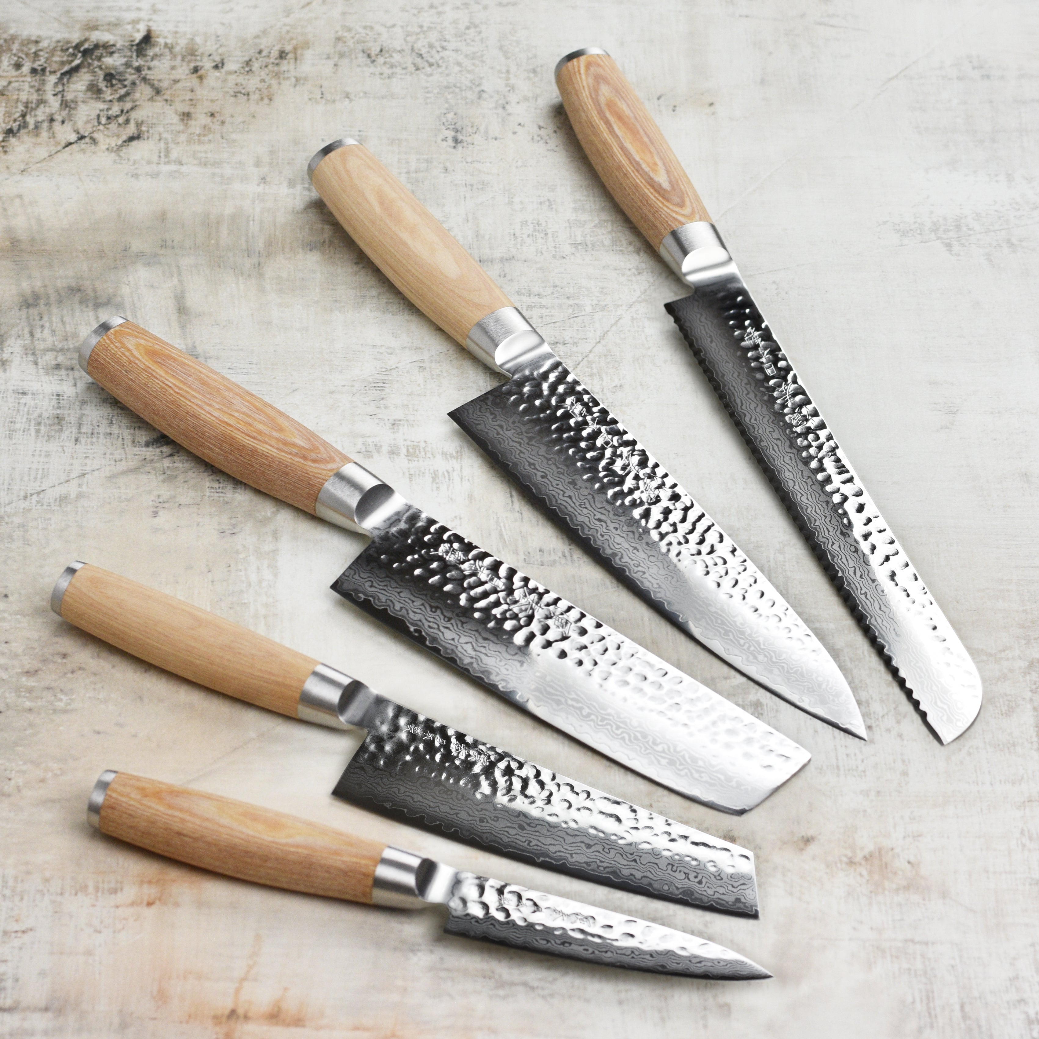 Top-down shot of knife set on a cutting board, highlighting blade shine and ergonomic handles