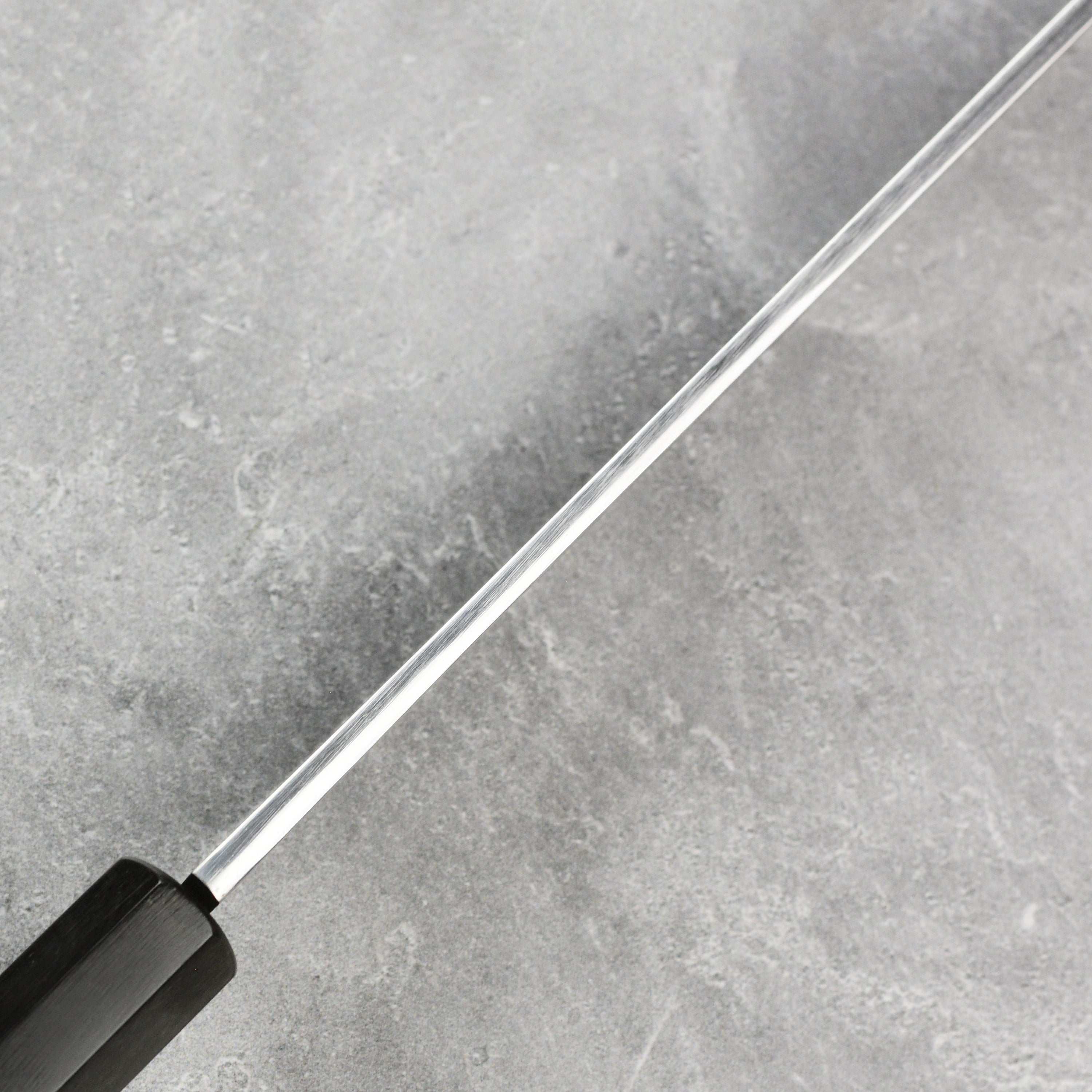 Premium chef knife with saya displayed elegantly on a kitchen countertop.