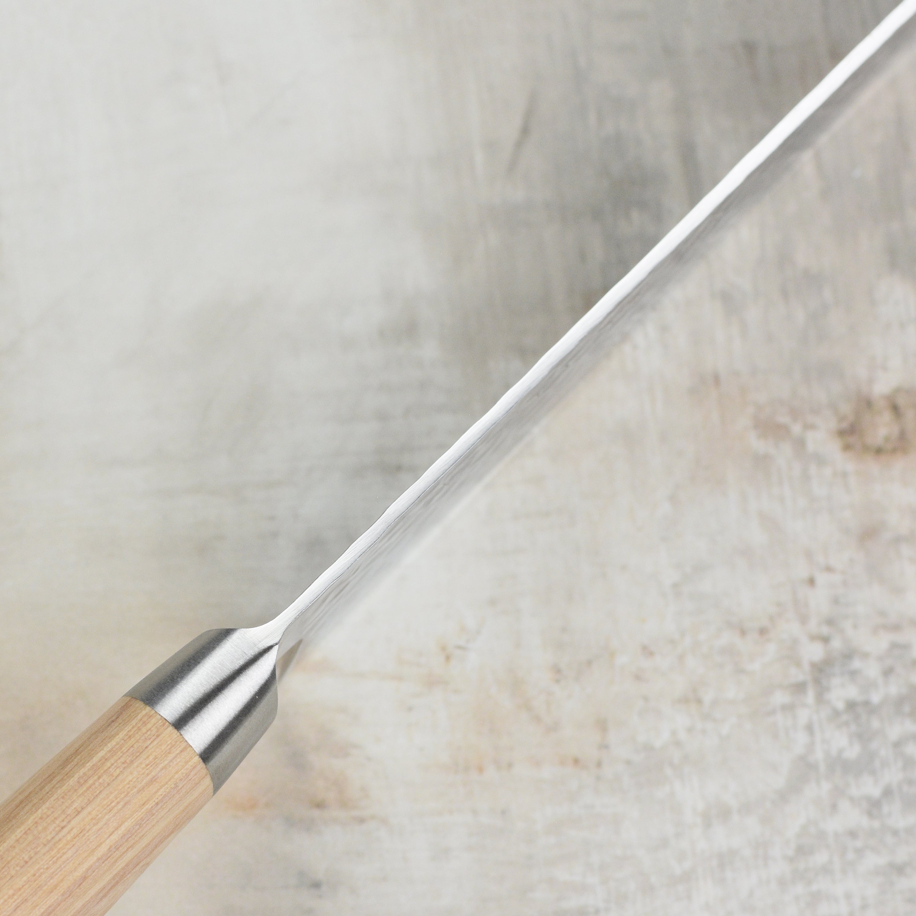 Side view of Enso Damascus chef knives displayed in a block, showing hammered finish and engraved end caps