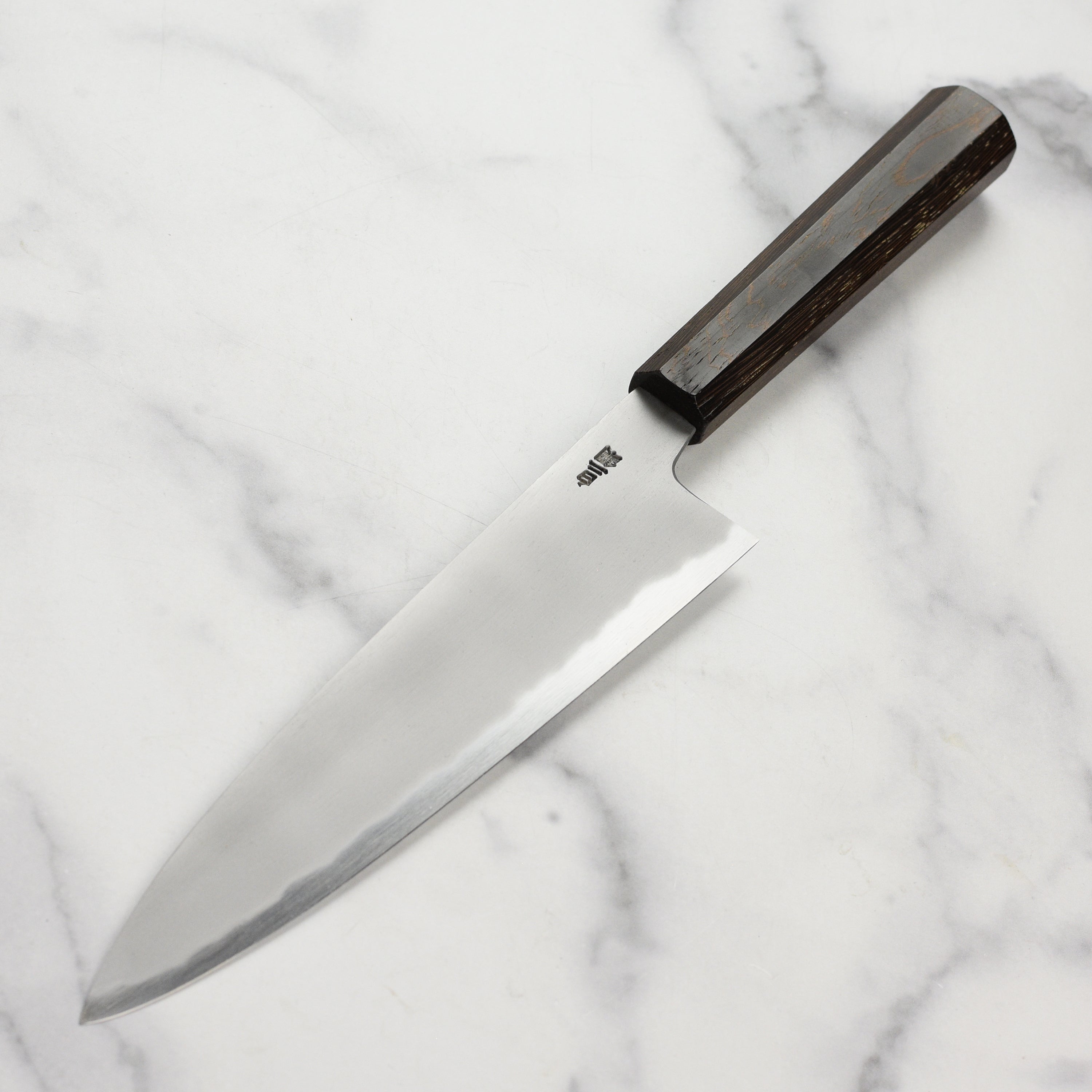 Chef slicing vegetables with the Takayuki Gyuto for precise cuts in a professional kitchen