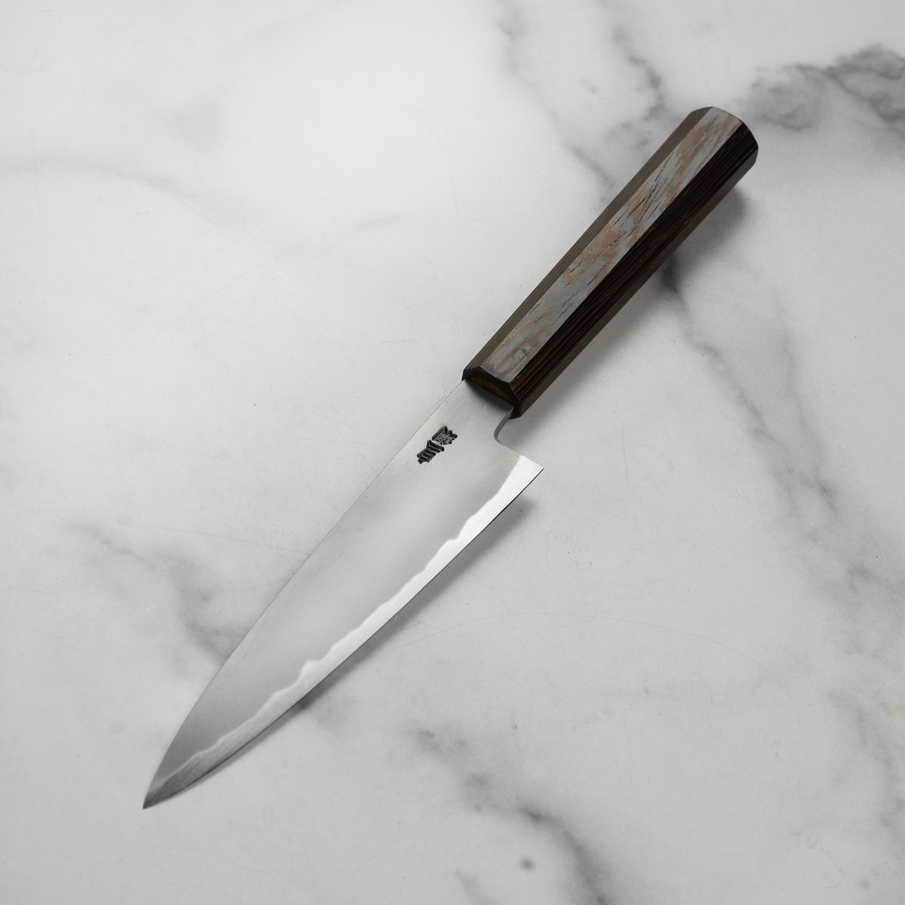 Close-up of the Takayuki Shirogami petty knife highlighting its sharp blade and ergonomic handle.