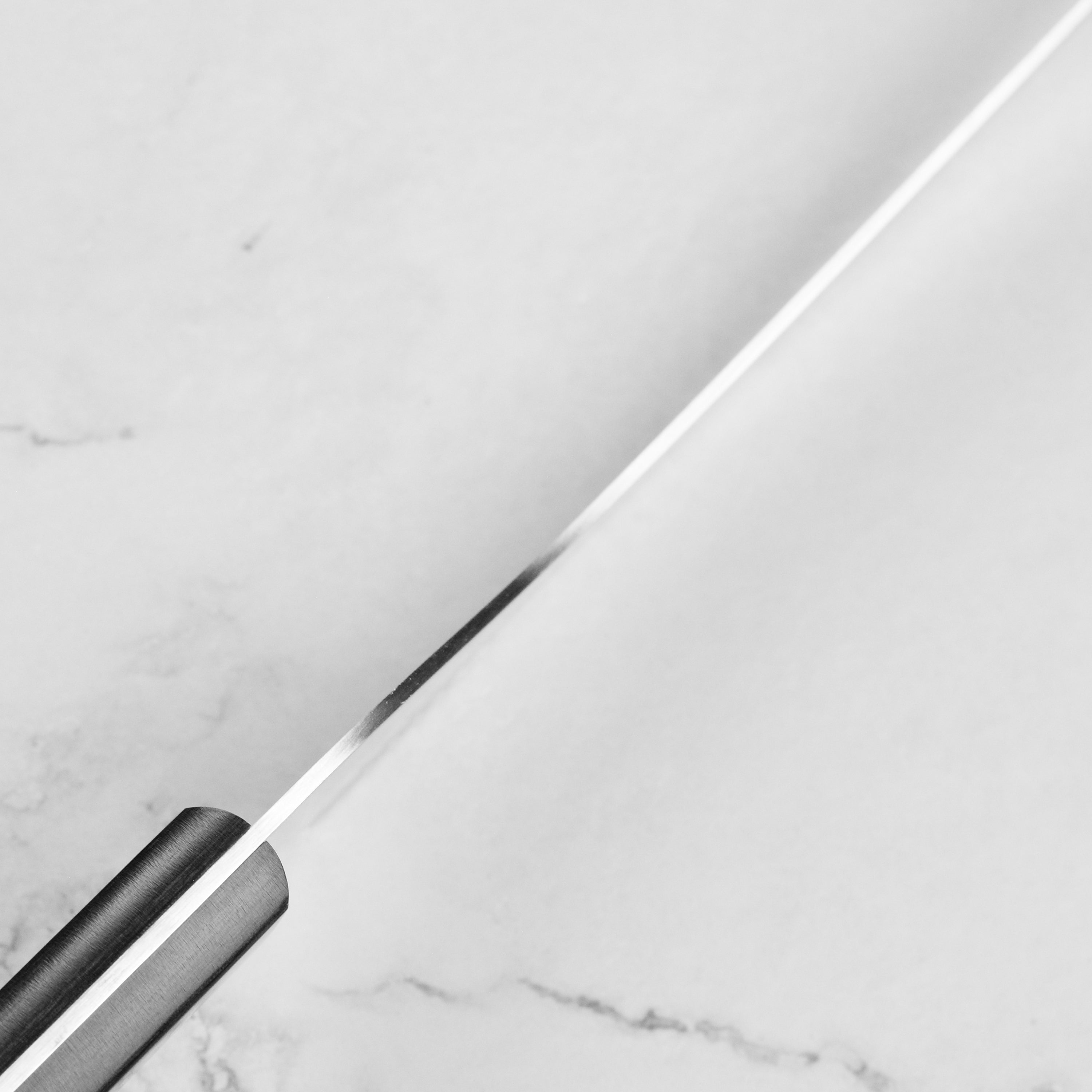 Chef slicing bread using a Japanese offset bread knife
