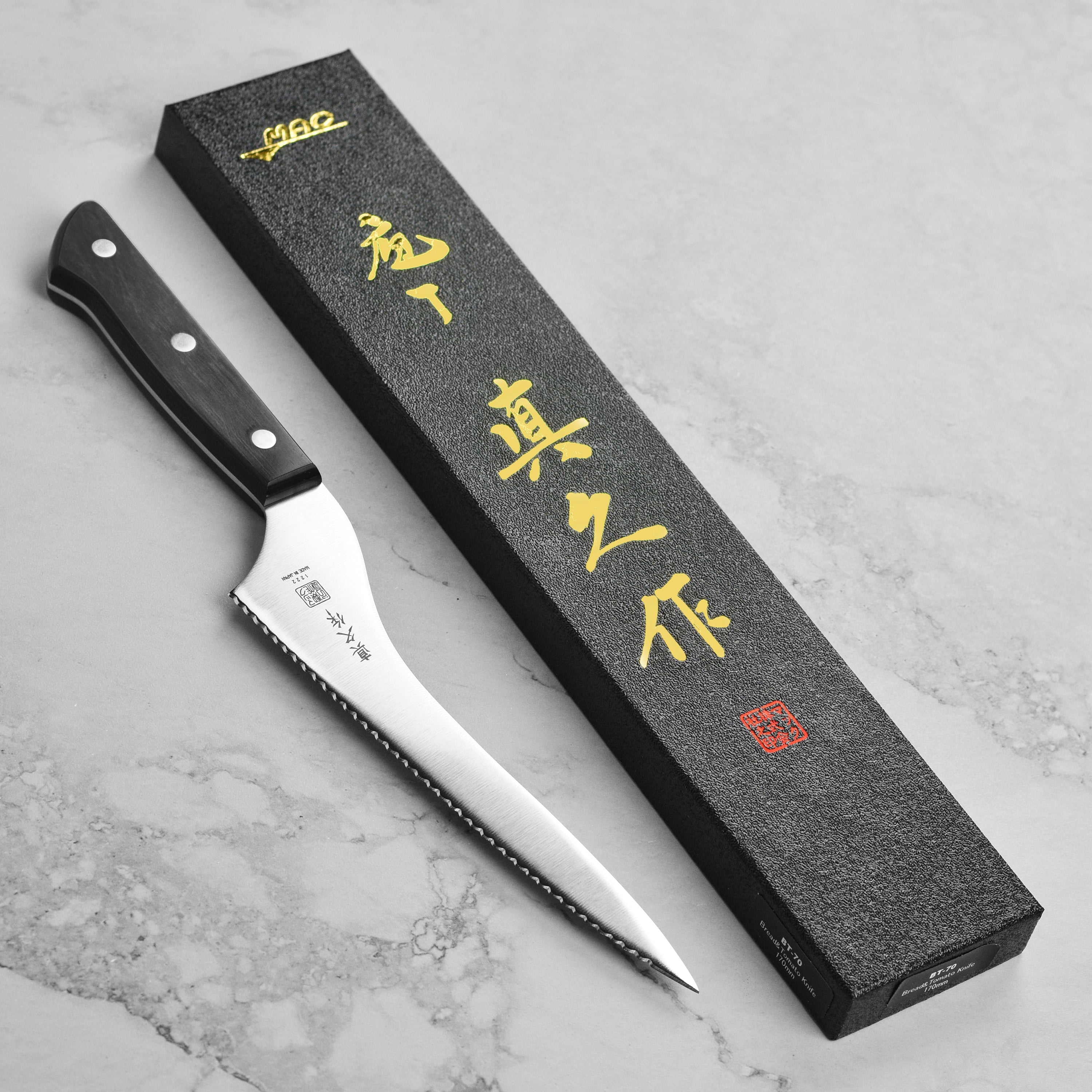 Chef slicing bread using a Japanese offset bread knife