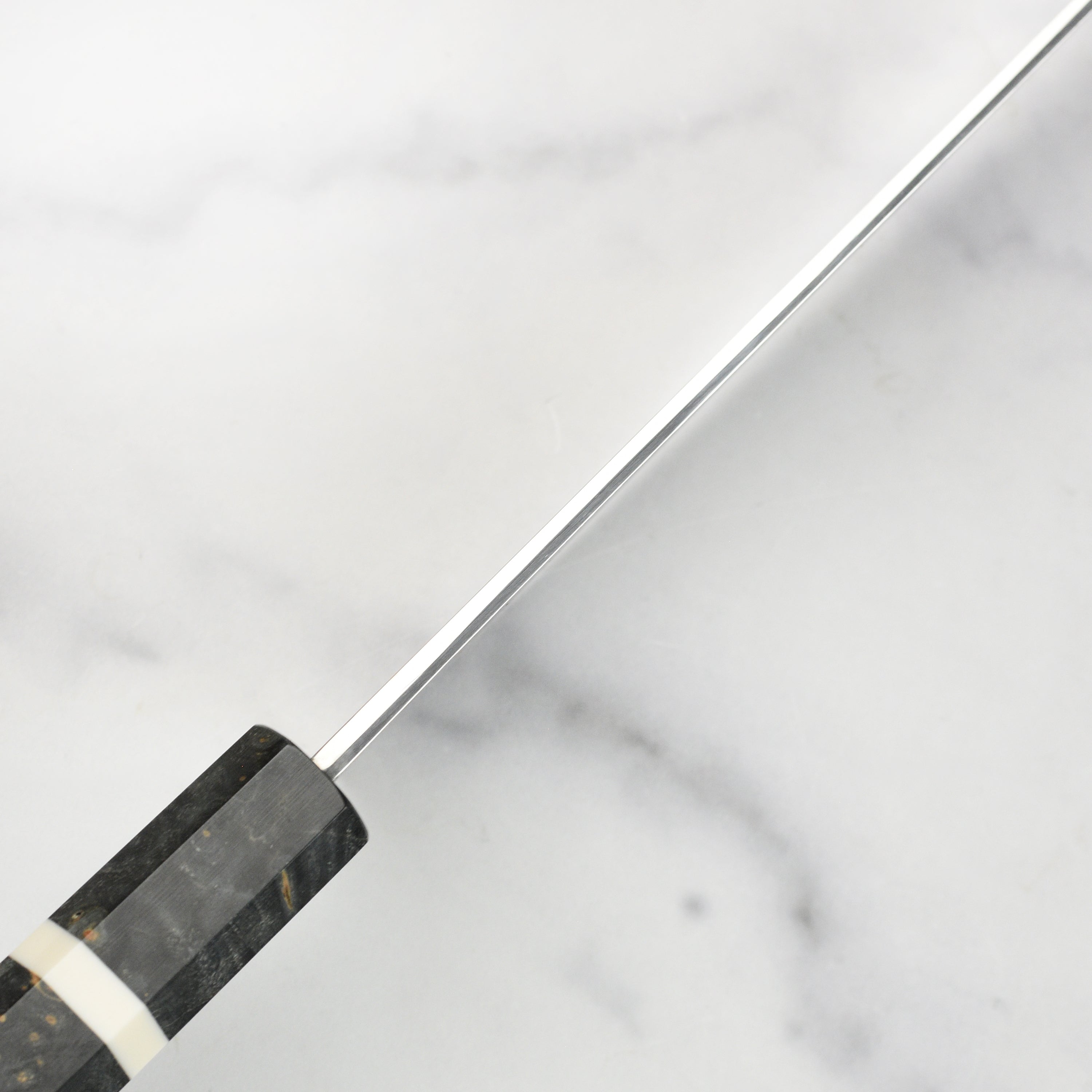 Elegant handle and full length of the damascus chef knife on a wooden cutting board