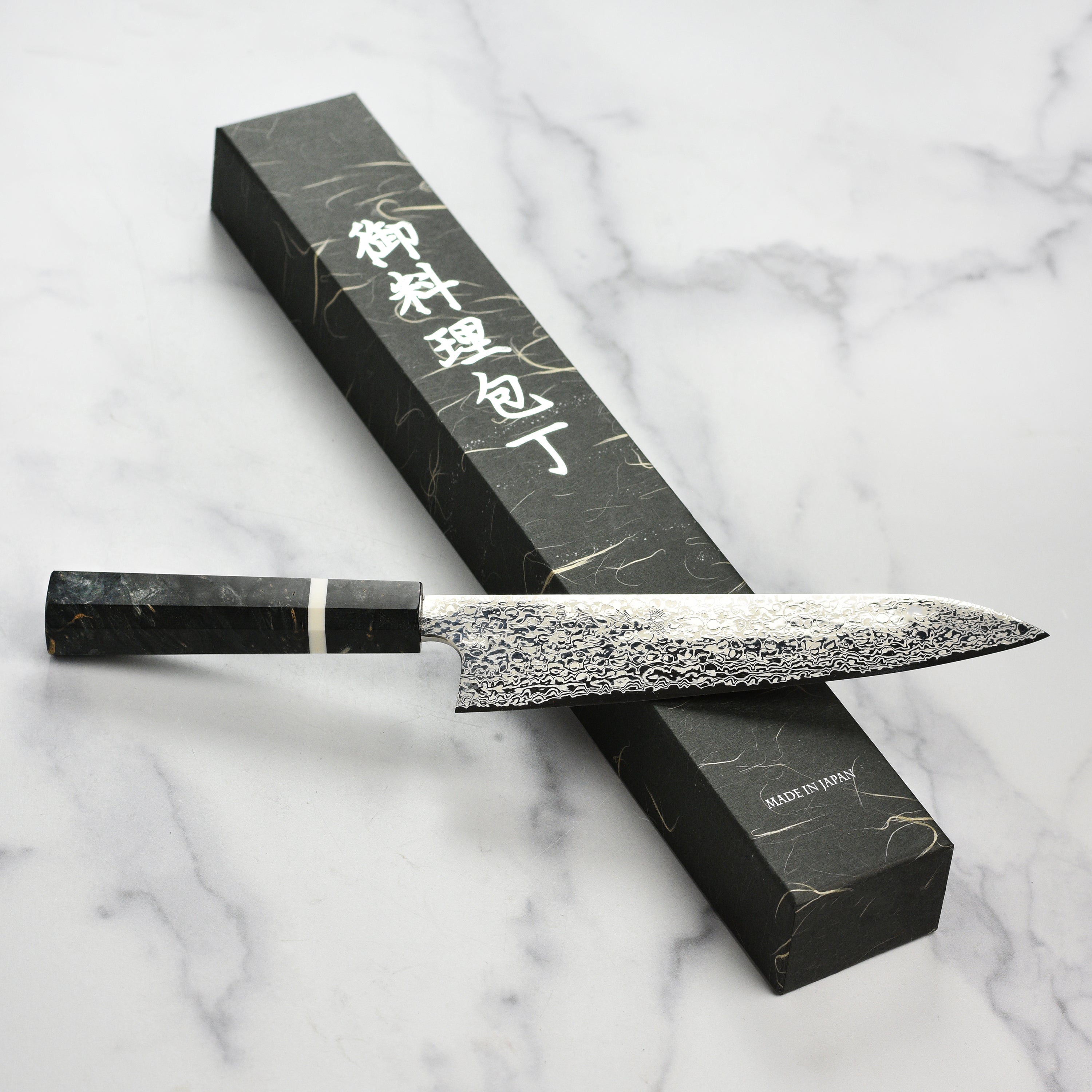 Elegant handle and full length of the damascus chef knife on a wooden cutting board
