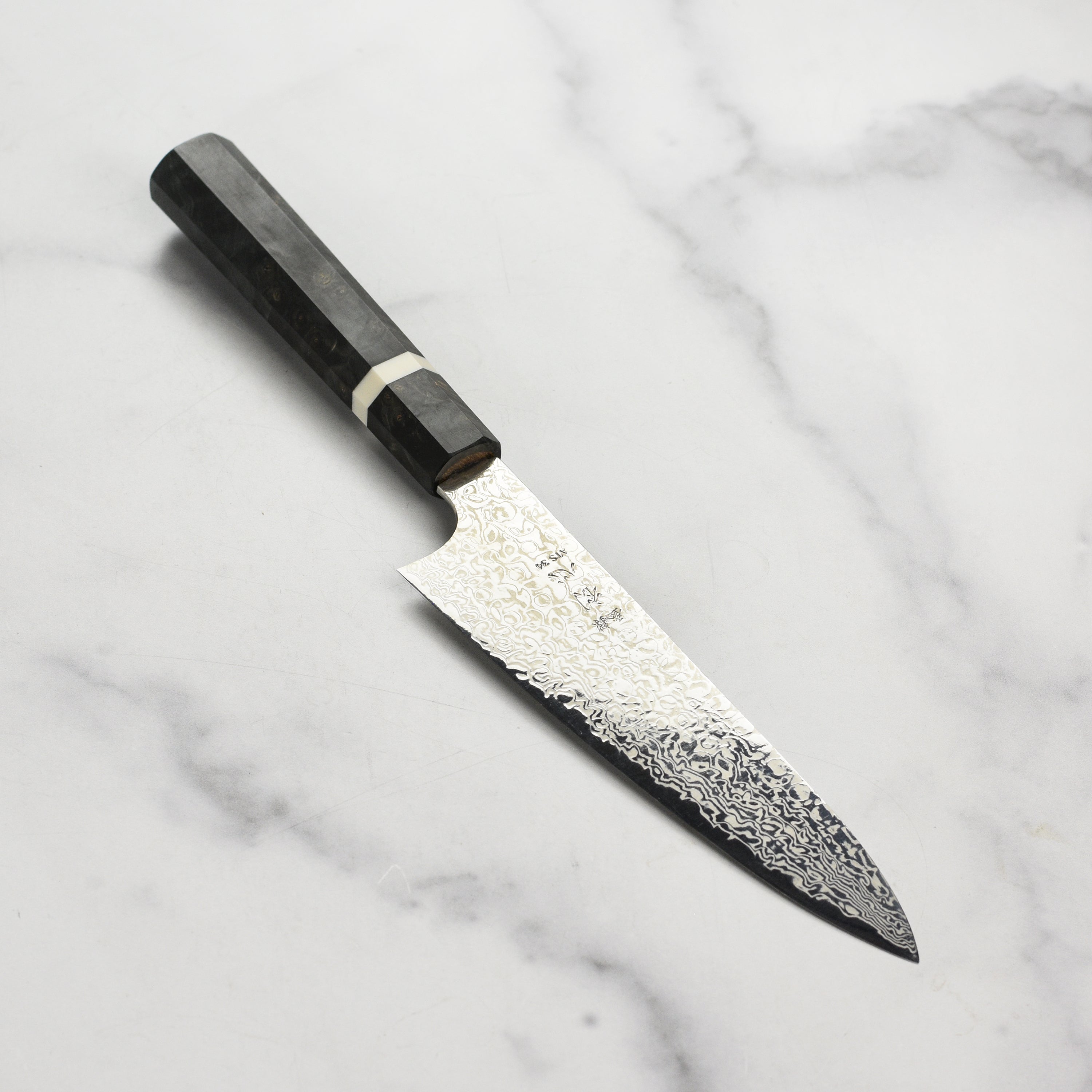 Hatsukokoro Ginga34 Damascus Petty Knife displayed on a wooden cutting board.