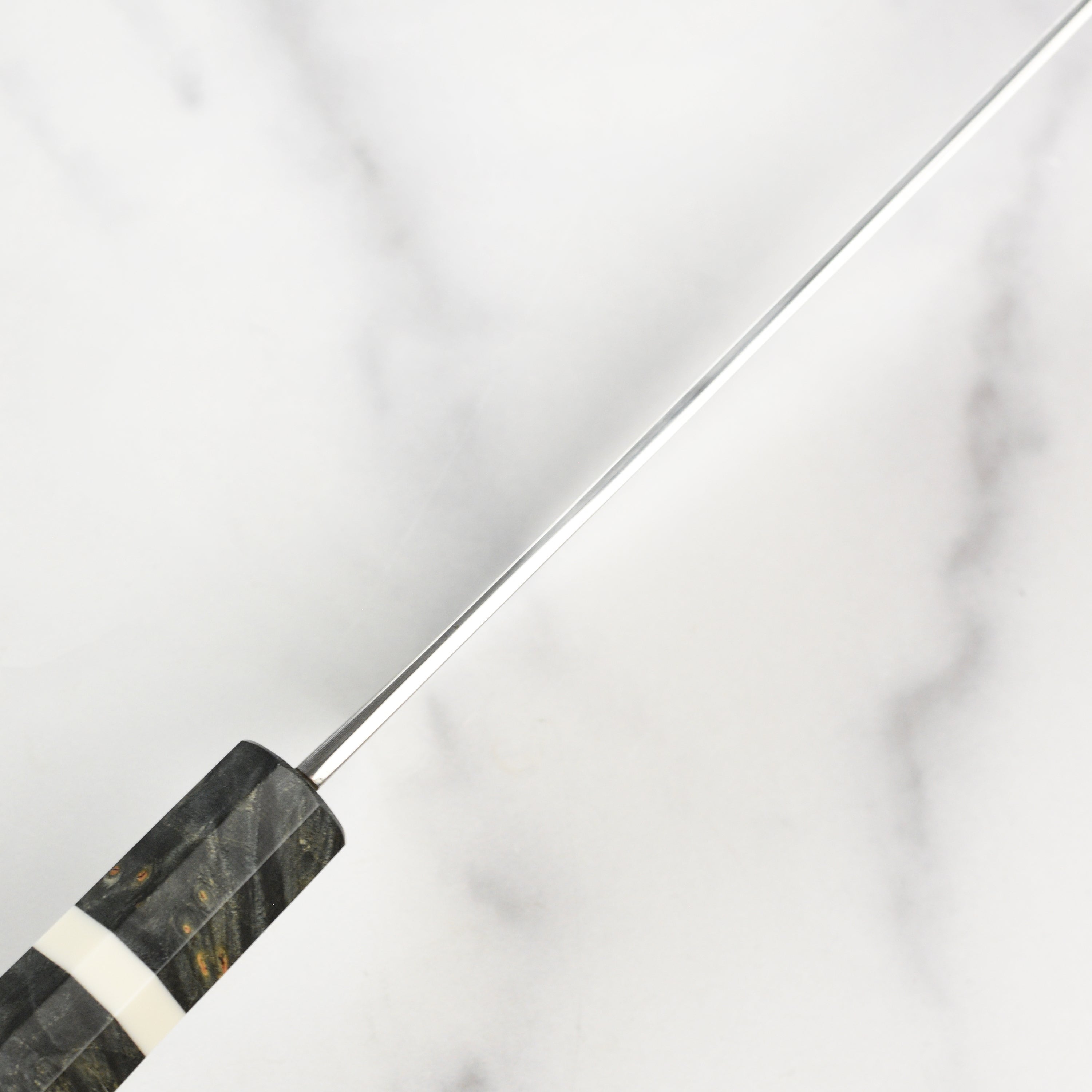 Close-up view of the blade of the Hatsukokoro Damascus knife, showcasing its intricate design.