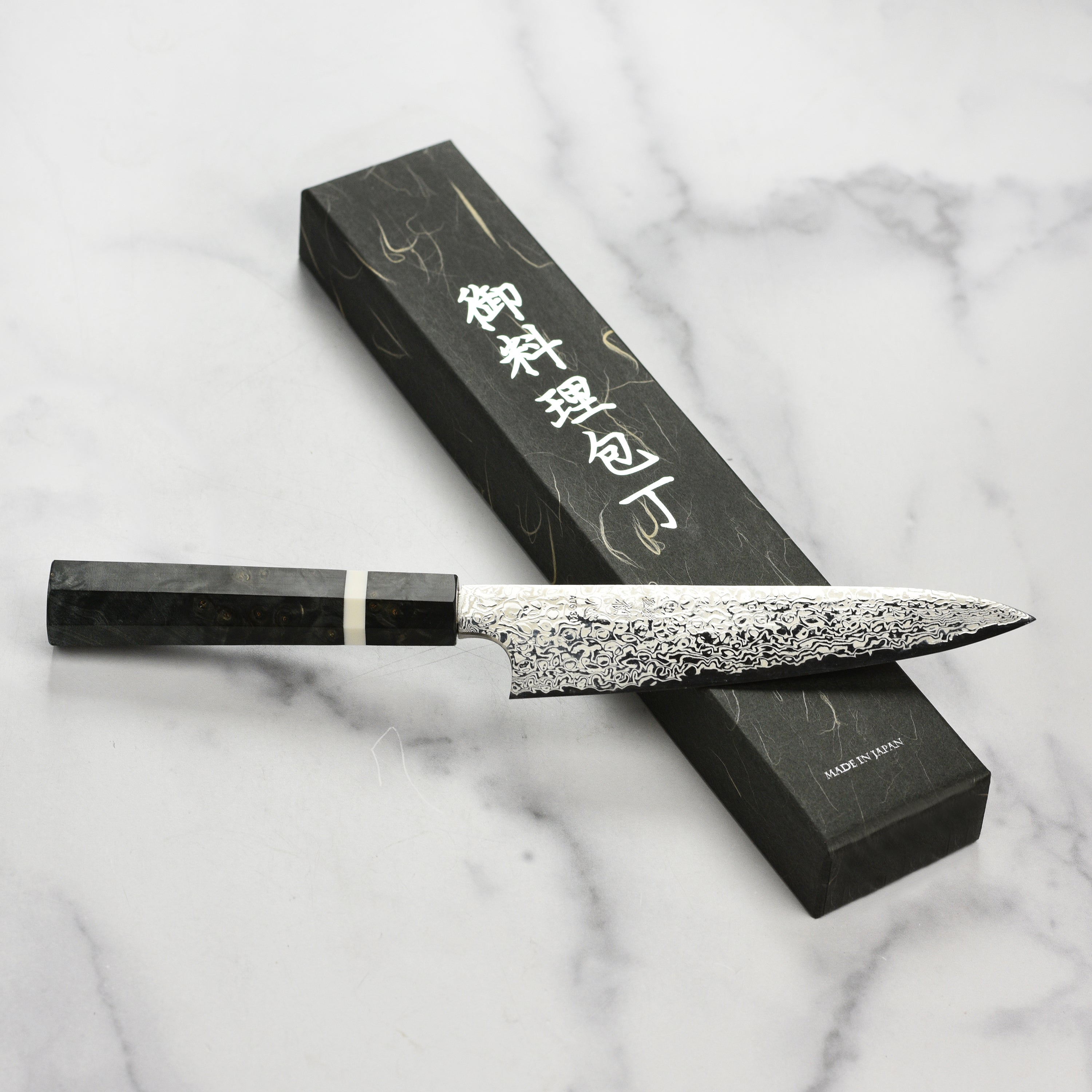 Close-up view of the blade of the Hatsukokoro Damascus knife, showcasing its intricate design.