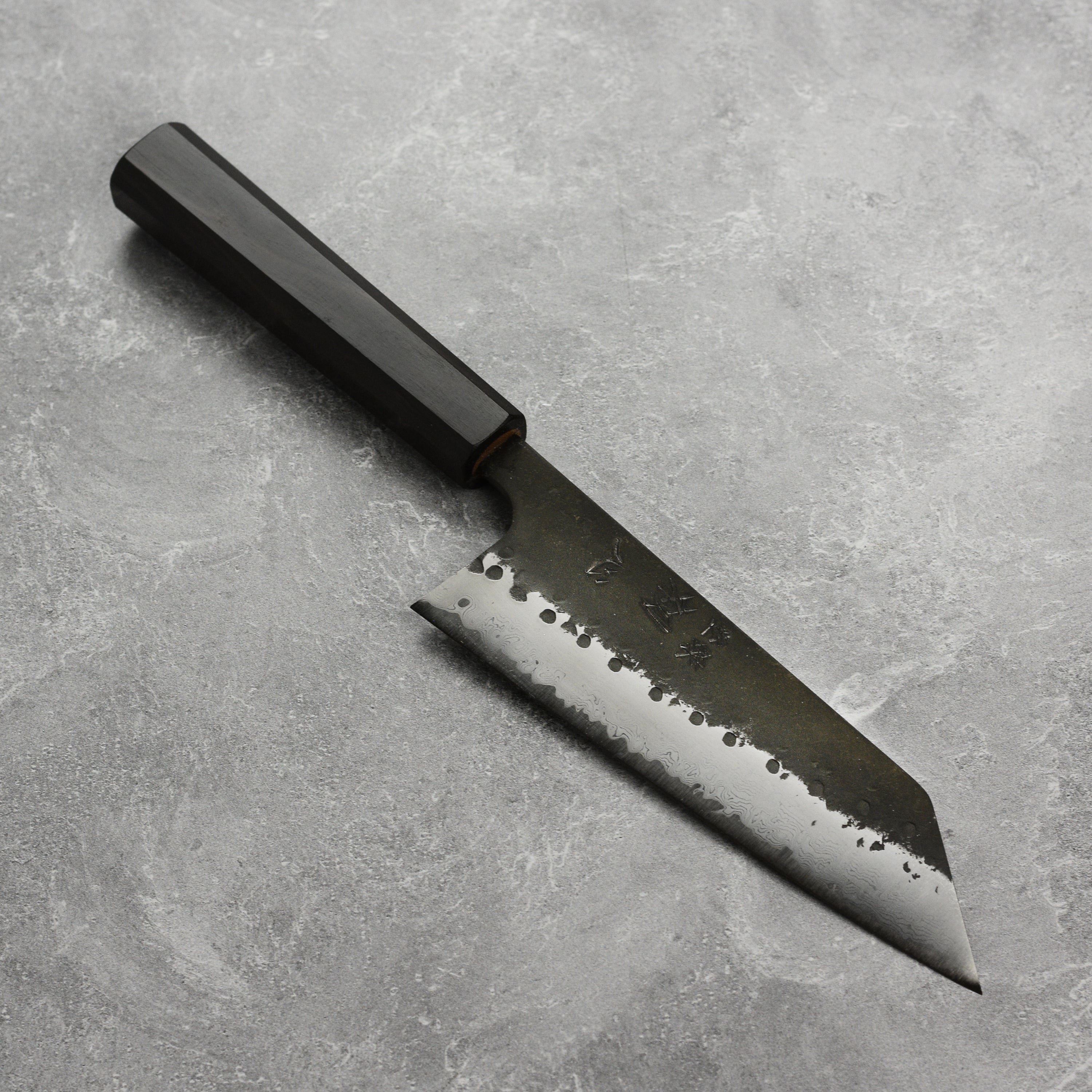 Hatsukokoro Aogami Super Bunka knife showing the blade's detailed Damascus pattern from an angled view.