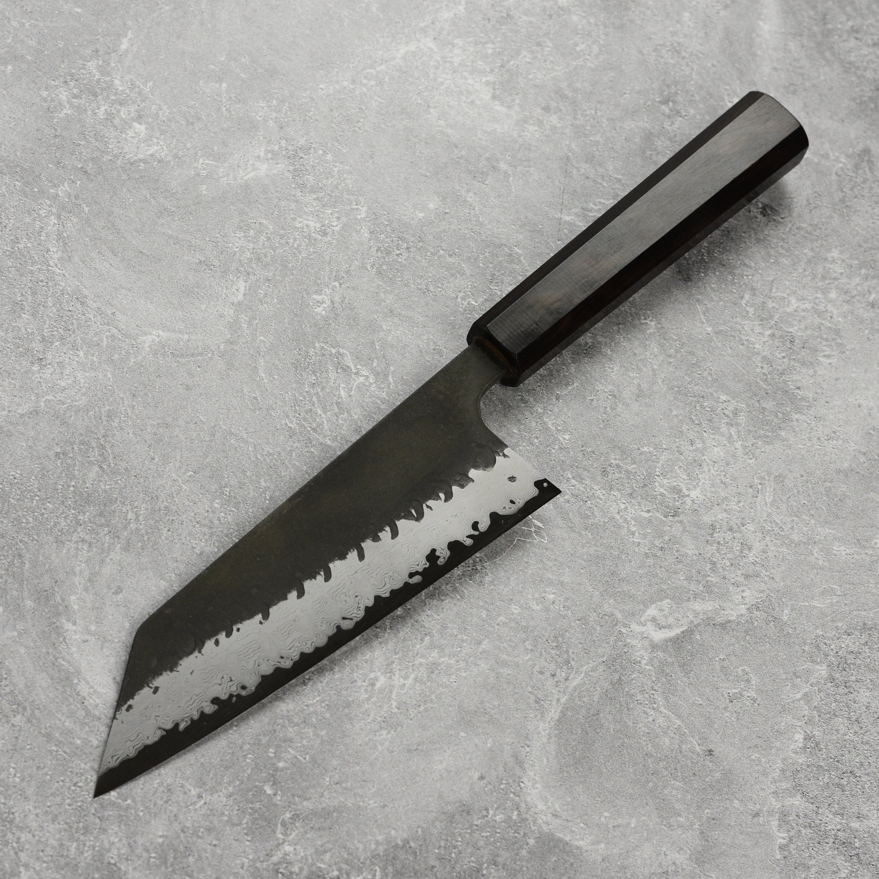 Hatsukokoro Aogami Super Bunka knife showing the blades detailed Damascus pattern from an angled view.