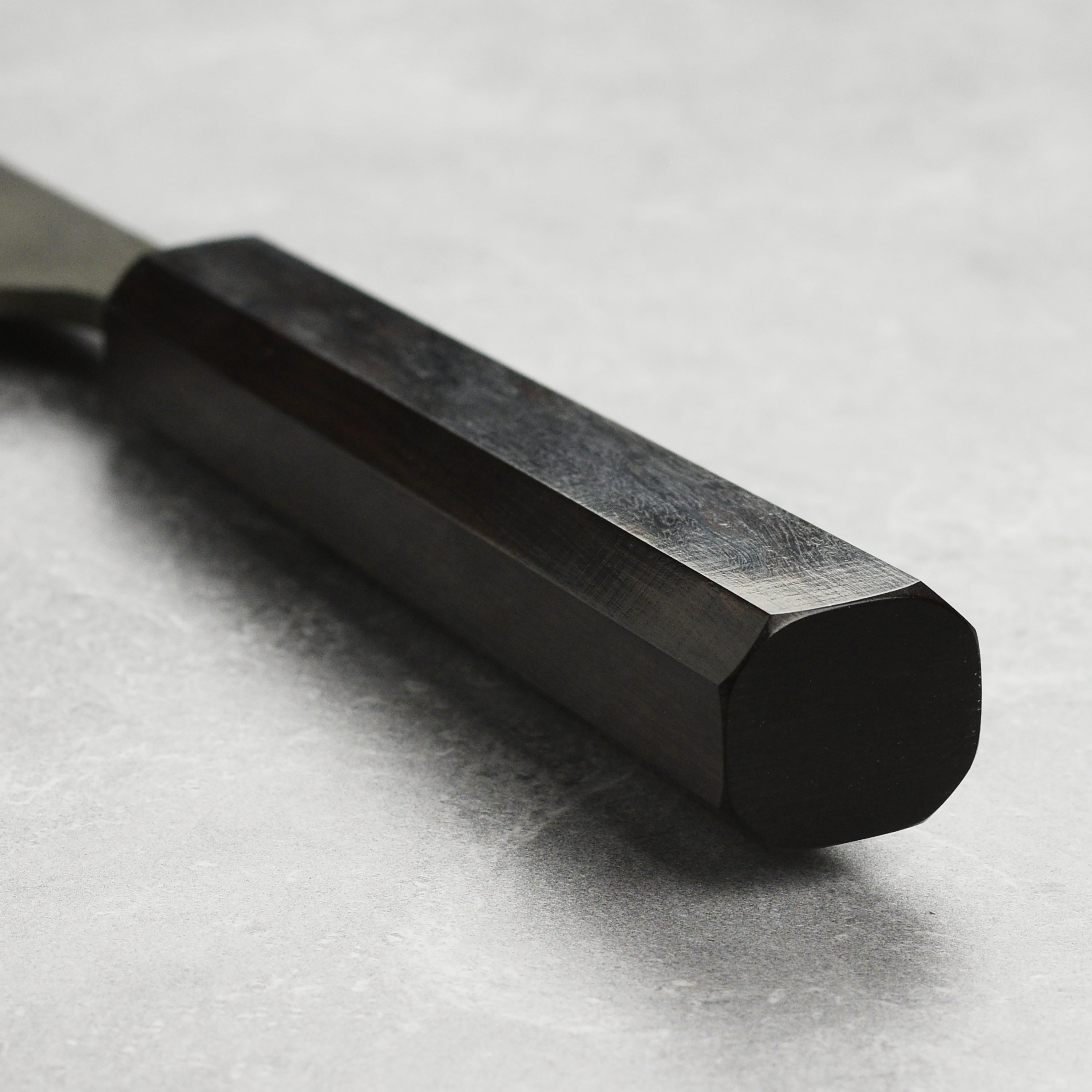 Close-up of the ebony handle of the Bunka knife, highlighting its ergonomic design for comfortable use.