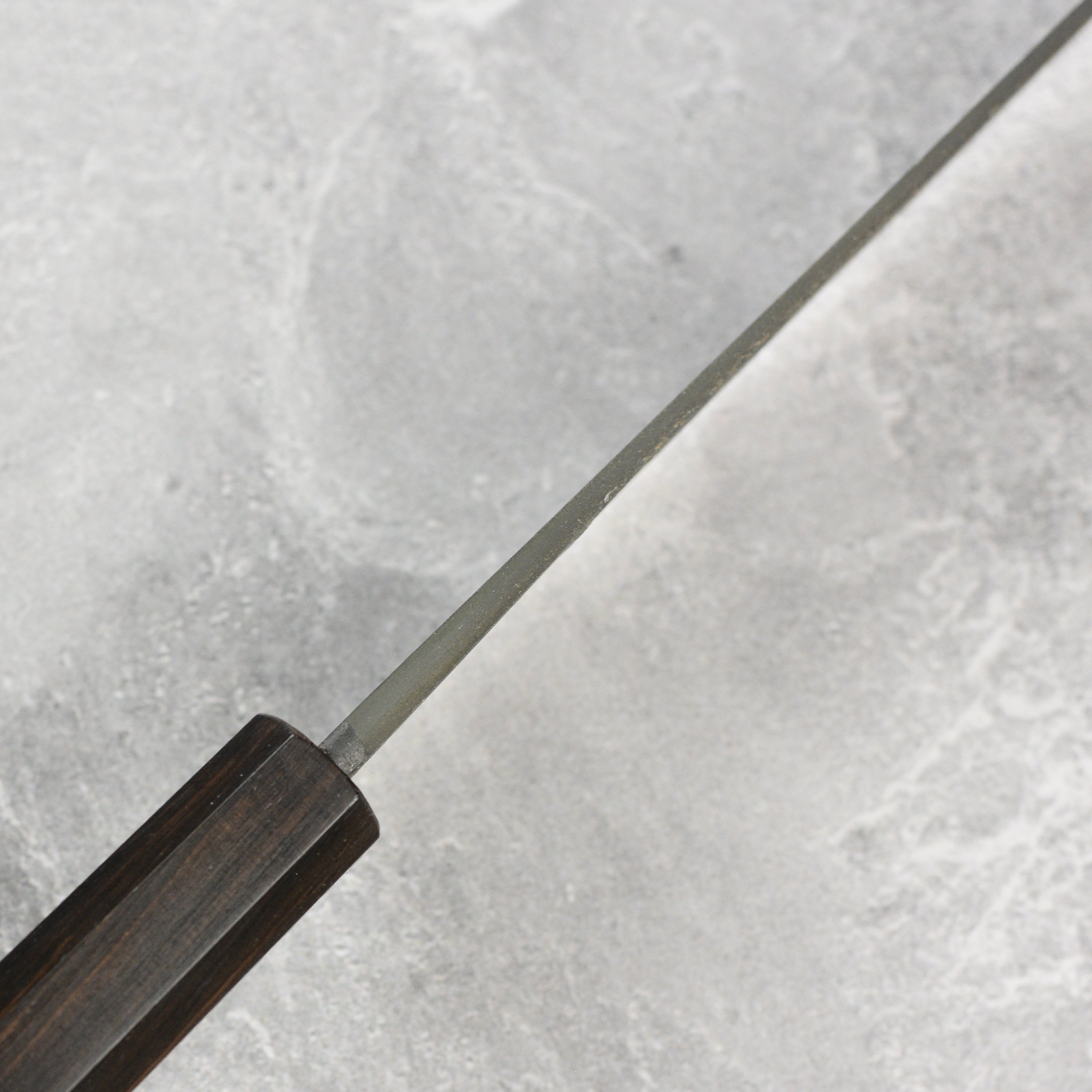 Bunka knife in action, slicing fresh vegetables on a wooden cutting board.