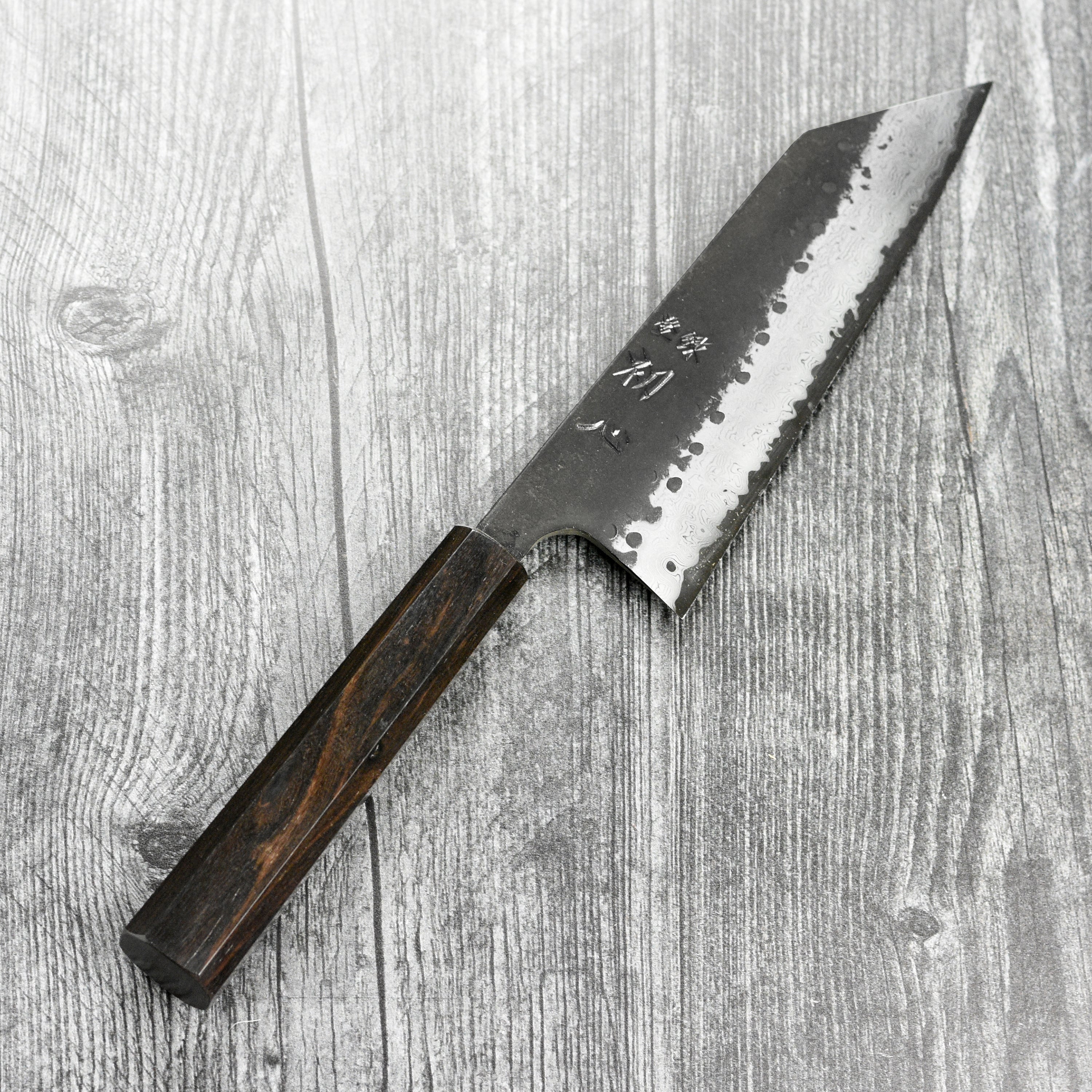 Bunka knife in action, slicing fresh vegetables on a wooden cutting board.