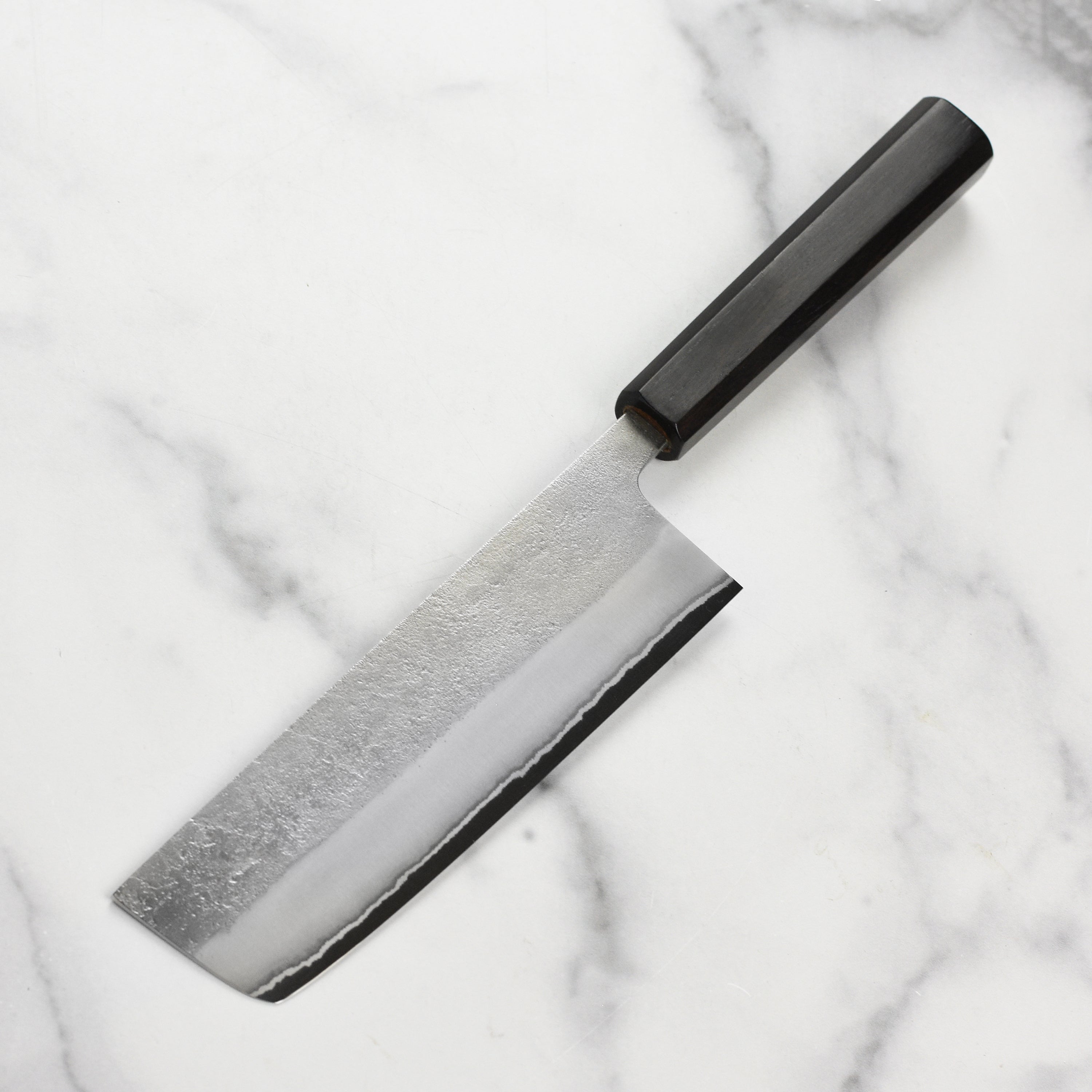 Close-up of the Yoshikane Nakiri Knife showcasing its sharp edge and ergonomic design.