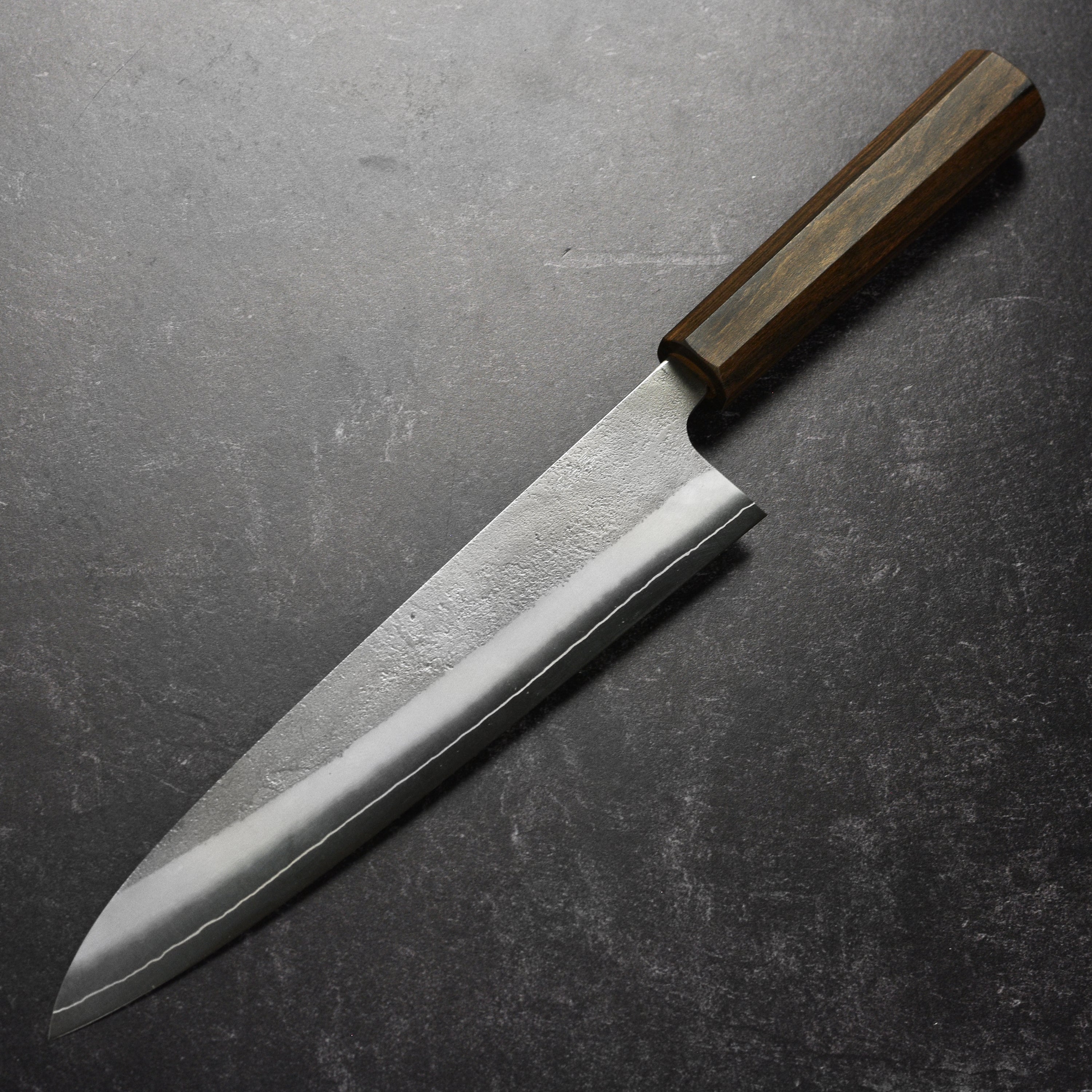 Close-up of the Yoshikane SKD Nashiji Gyuto Knifes handle, emphasizing its ergonomic grip and craftsmanship.