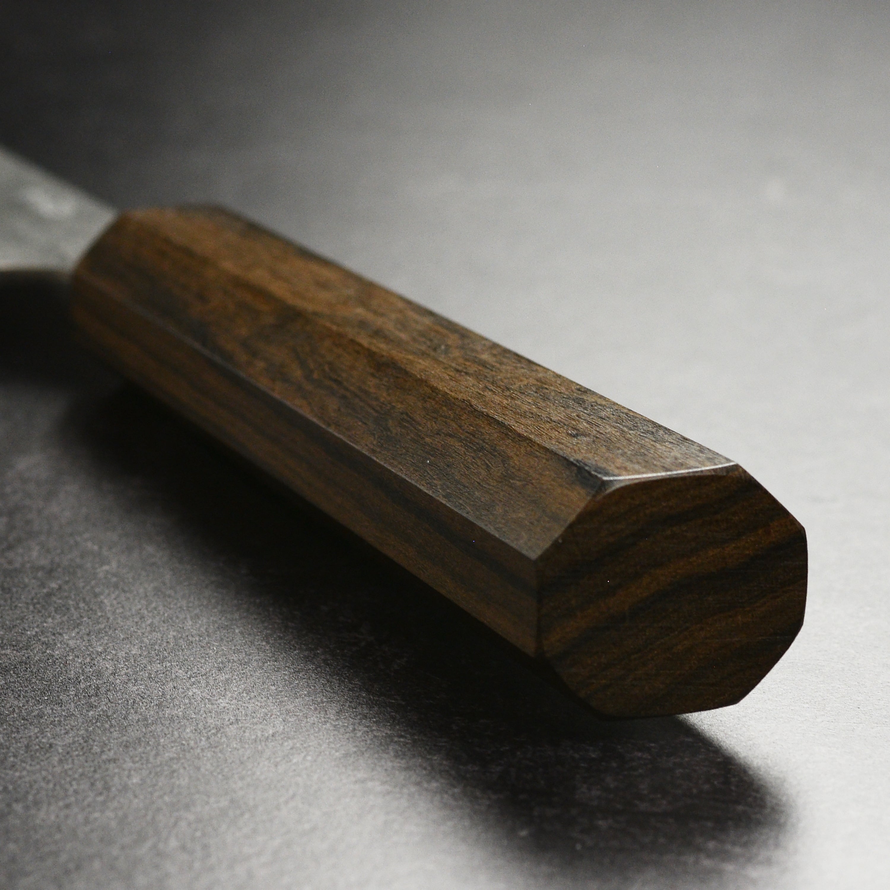 Close-up of the Yoshikane SKD Nashiji Gyuto Knifes handle, emphasizing its ergonomic grip and craftsmanship.