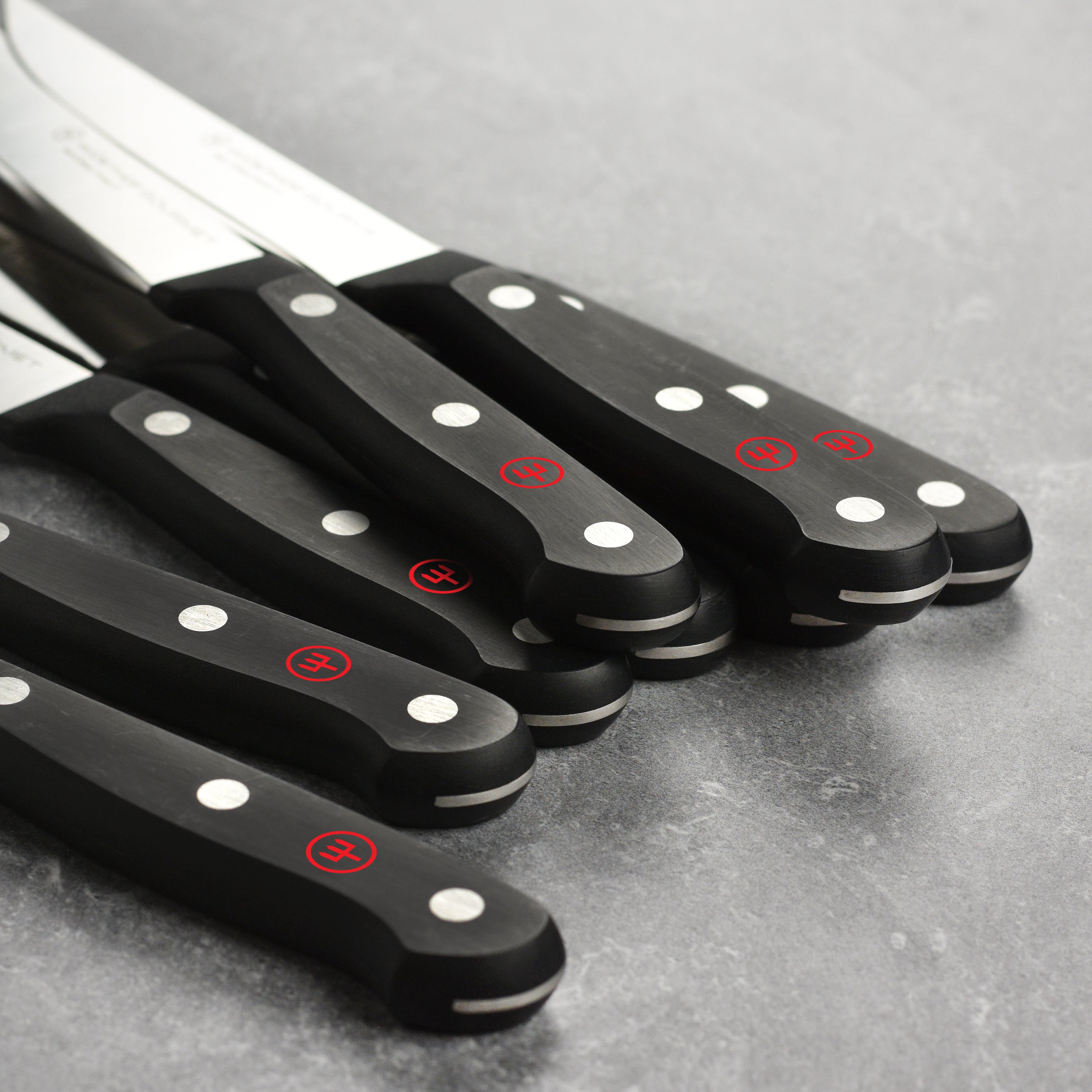 Chef slicing steak with Wusthof gourmet steak knives showing precision and sharpness