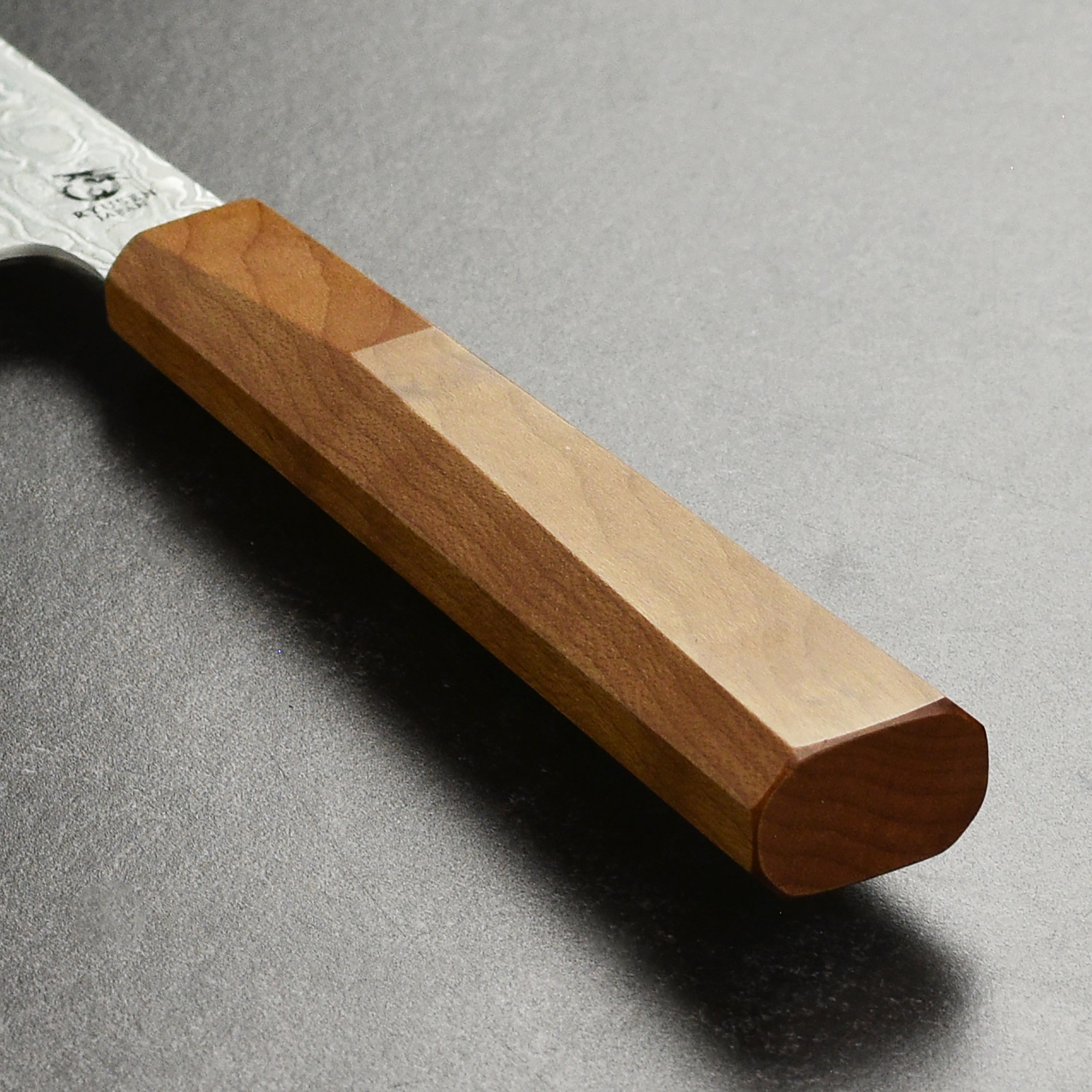 Professional chef using a Japanese knife to chop vegetables in a modern kitchen